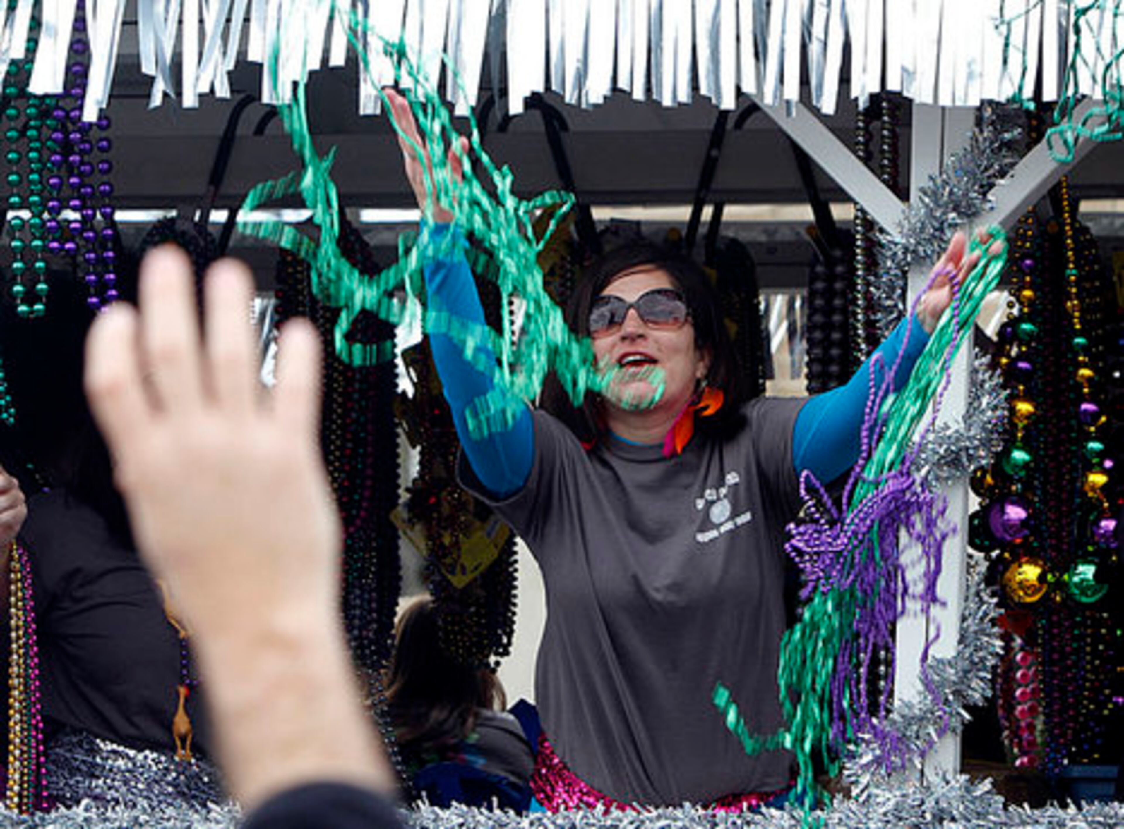 Beads are thrown off a float as it passes by on Davis Street during the St. Paul Carnival Association parade in Pass Christian, Miss., Sunday, Feb. 19, 2012.