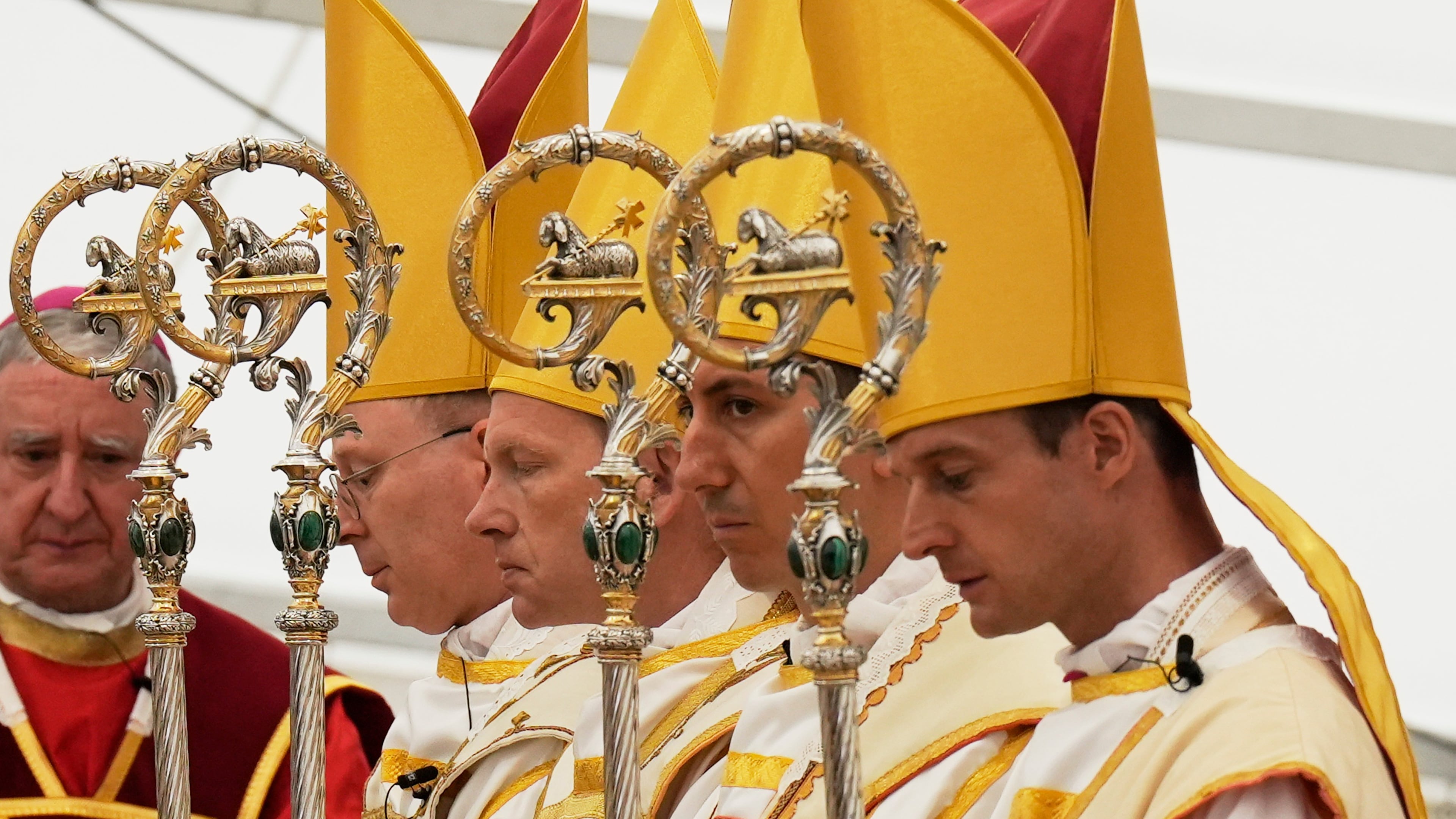 Newly consecrated bishops, from left, Pascal Schreiber, Michael Goldade, Michel Poinsinet de Sivry and Marc Hanappier, wearing their miters and holding their pastoral staffs, pray at the end of their consecration ceremony in a tent set up outside the Society of St. Pius X seminary in Econe, Switzerland, Wednesday, July 1, 2026. (AP Photo/Baz Ratner)