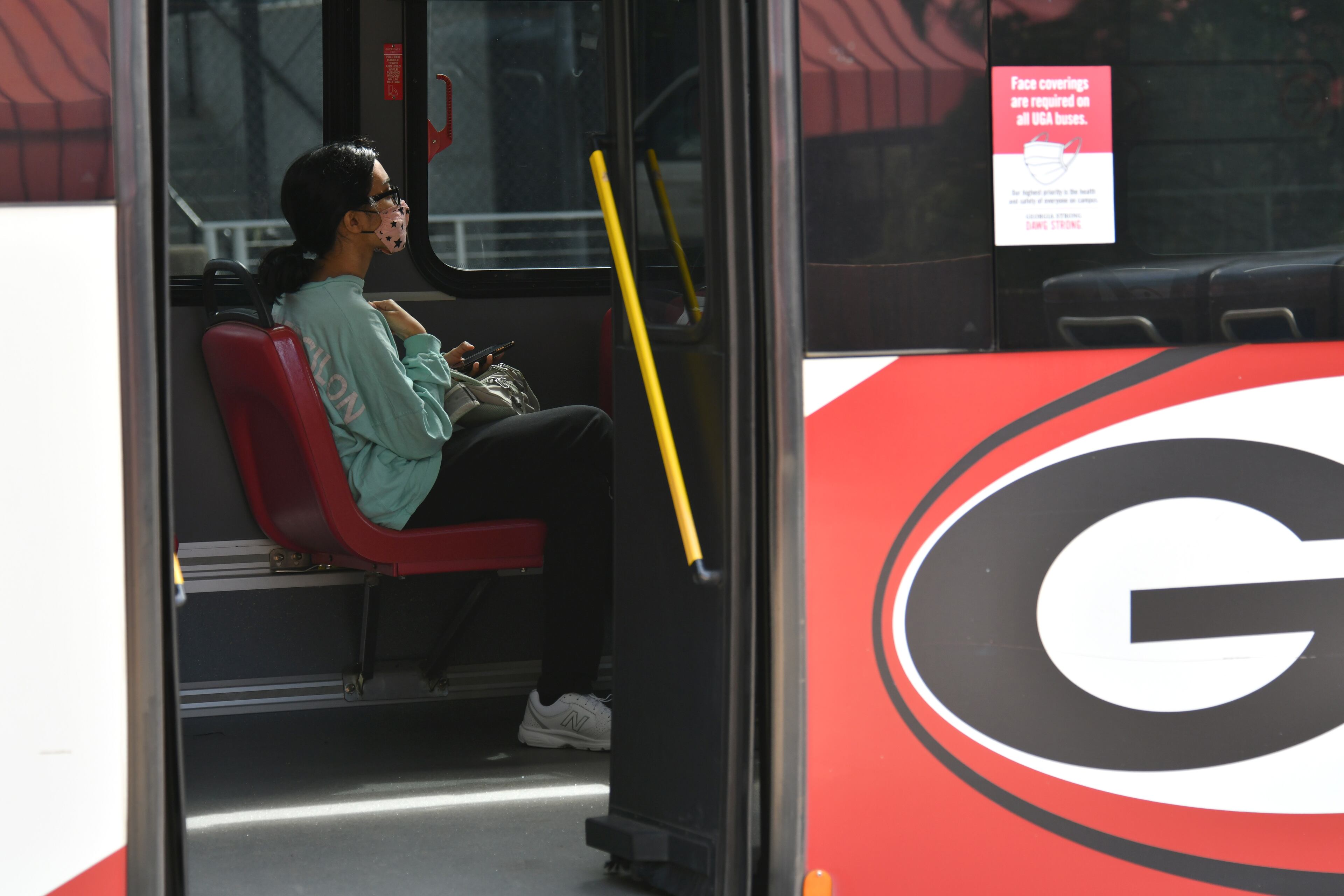 A student wears a face mask as she sits in an University of Georgia bus on the campus in Athens on Wednesday, September 23, 2020. (Hyosub Shin / Hyosub.Shin@ajc.com)