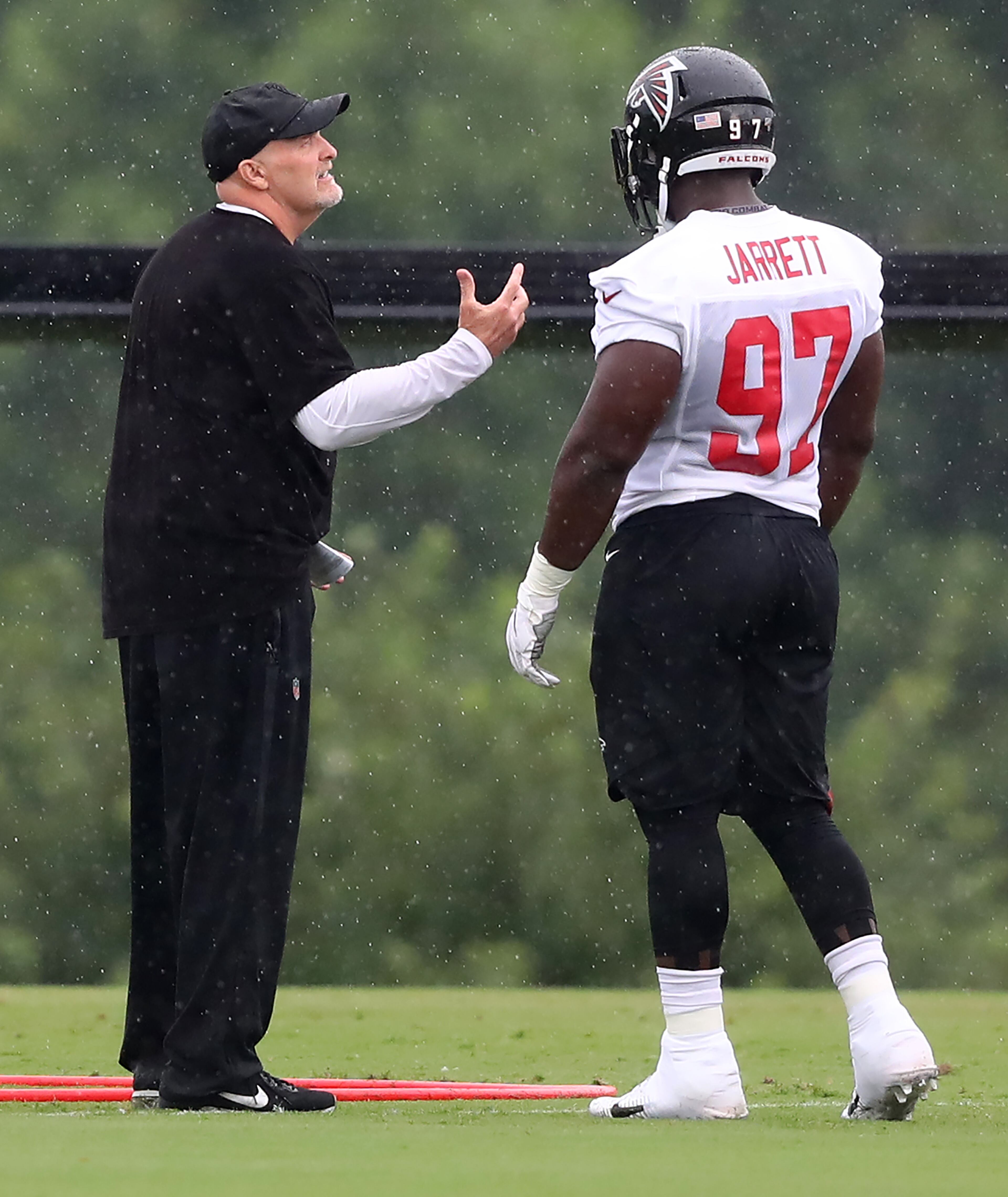 Coach Dan Quinn works with Grady Jarrett. Curtis Compton/ccompton@ajc.com