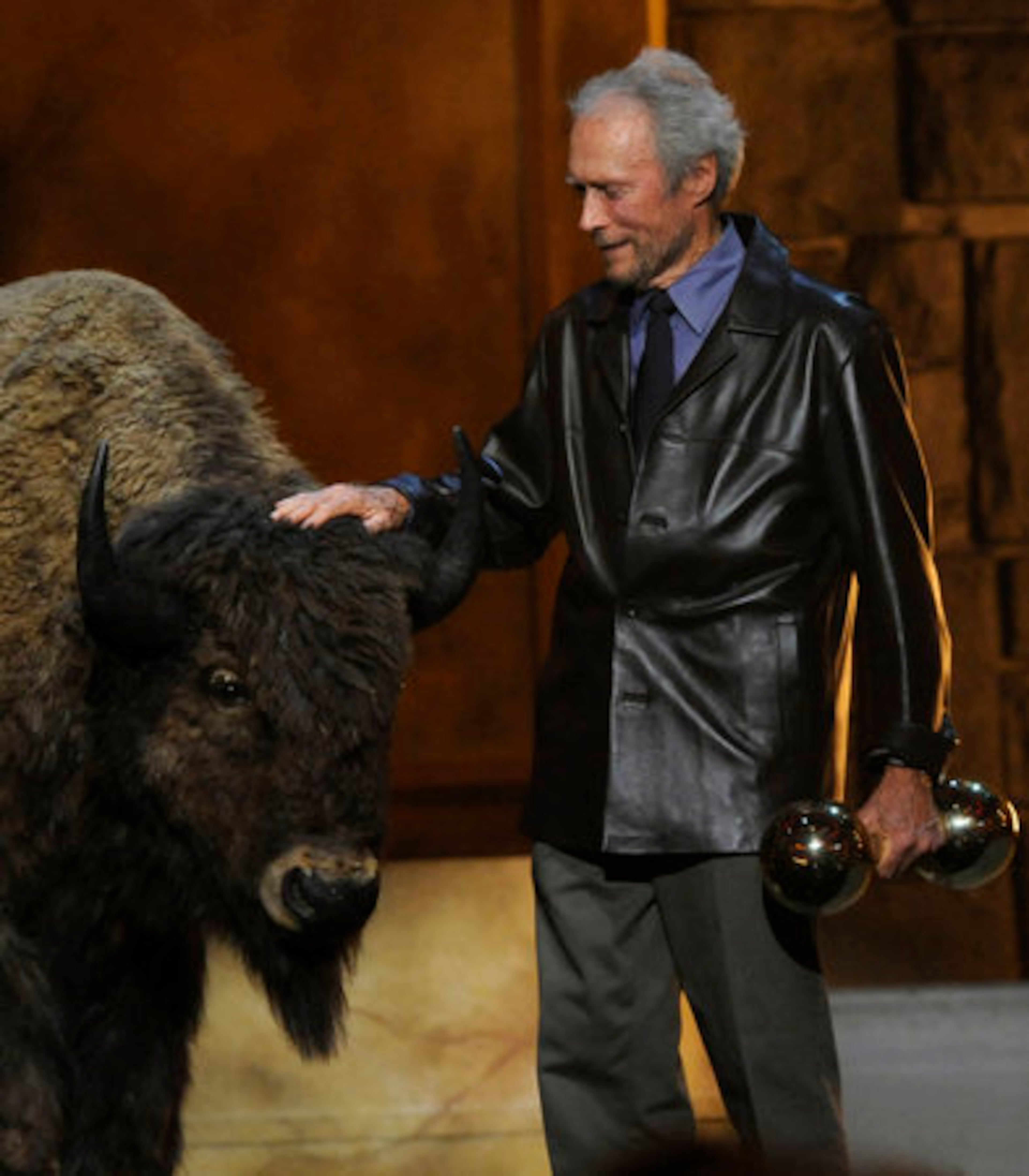 Clint Eastwood pets a buffalo after picking up his Brass Balls Award.
