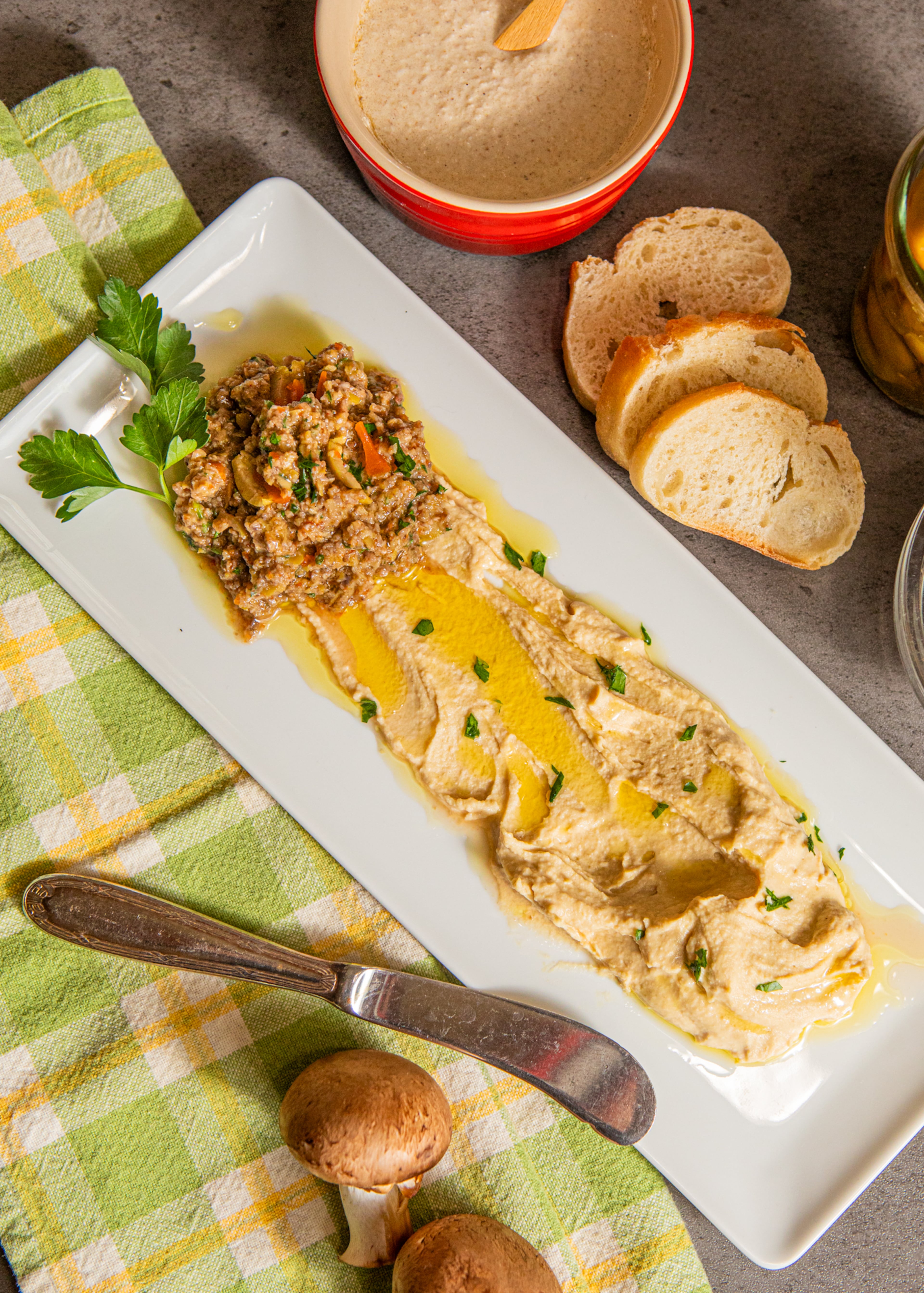 For a vegetable-forward lunch, snack or appetizer, enjoy Olive & Mushroom Tapenade paired with White Bean Hummus and crispy baguette slices. (Aaliyah Man for The Atlanta Journal-Constitution / food styling by Jennifer Hill Booker)