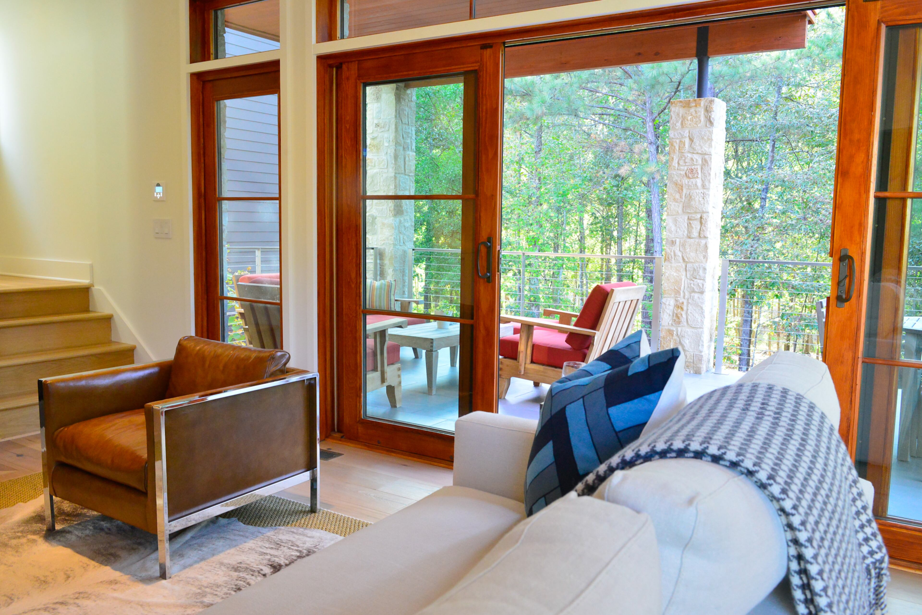 Sofa from ABC Home in New York City. Mid-century pair of original Milo Baughman club chairs purchased at West End in Napa, Calif. The chairs sit on a cowhide rug; a sculptured tree stump serves as a table.