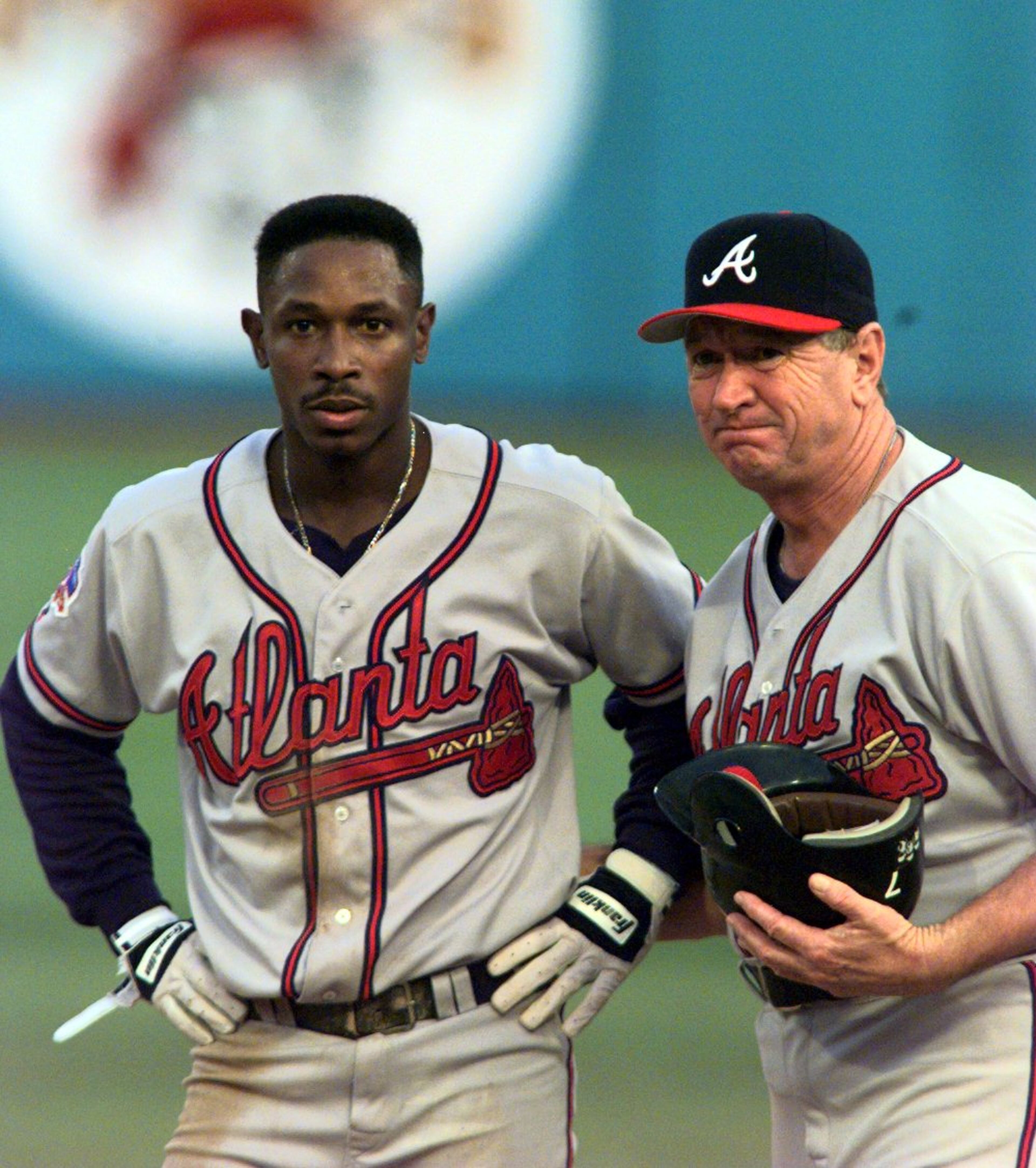 971012 - Miami, Florida - A stunned Kenny Lofton gets his batting helmet picked up by third base coach Bobby Dews after he was out stealing second in the 8th inning on October 12, 1997. Thrown out by Charles Johnson for the 3rd out of the 8th inning killing the Braves last rally. (AJC Staff Photo/W. A. Bridges, Jr.)