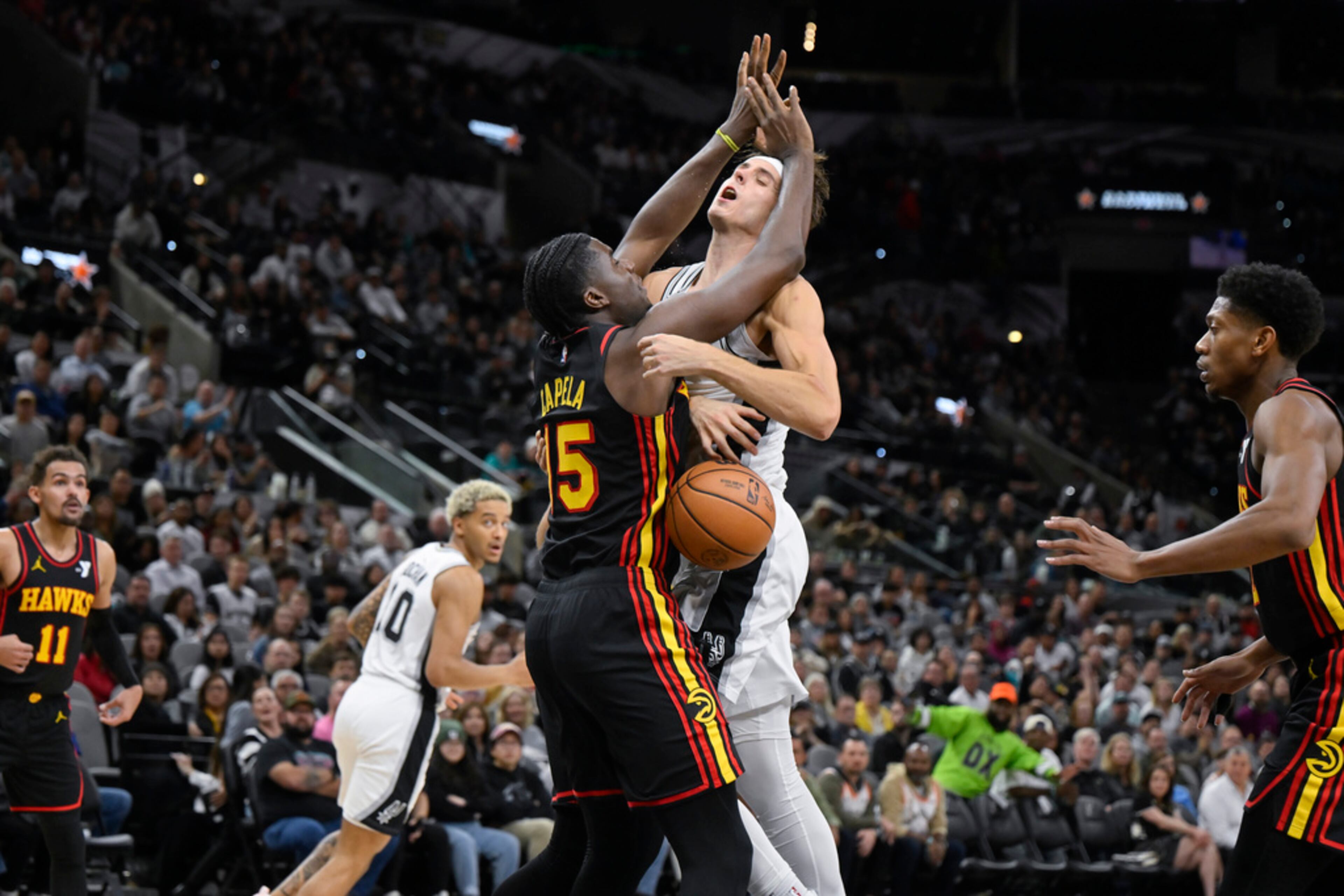 San Antonio Spurs' Zach Collins collides with Atlanta Hawks' Clint Capela (15) during the second half of an NBA basketball game Thursday, Nov. 30, 2023, in San Antonio. (AP Photo/Darren Abate)