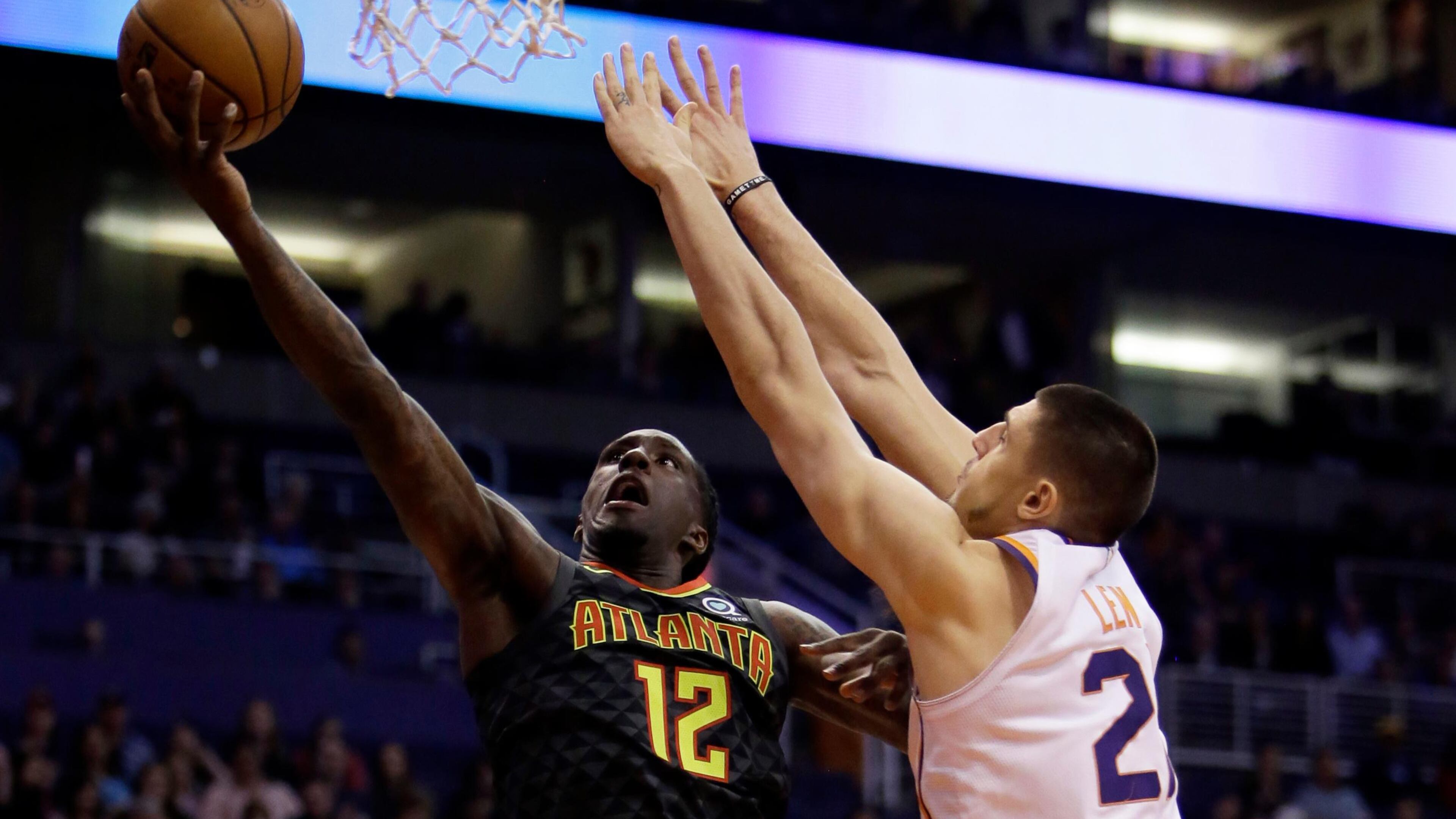 Atlanta Hawks forward Taurean Prince (12) drives past Phoenix Suns center Alex Len in the first half during an NBA basketball game, Tuesday, Jan. 2, 2018, in Phoenix. (AP Photo/Rick Scuteri)