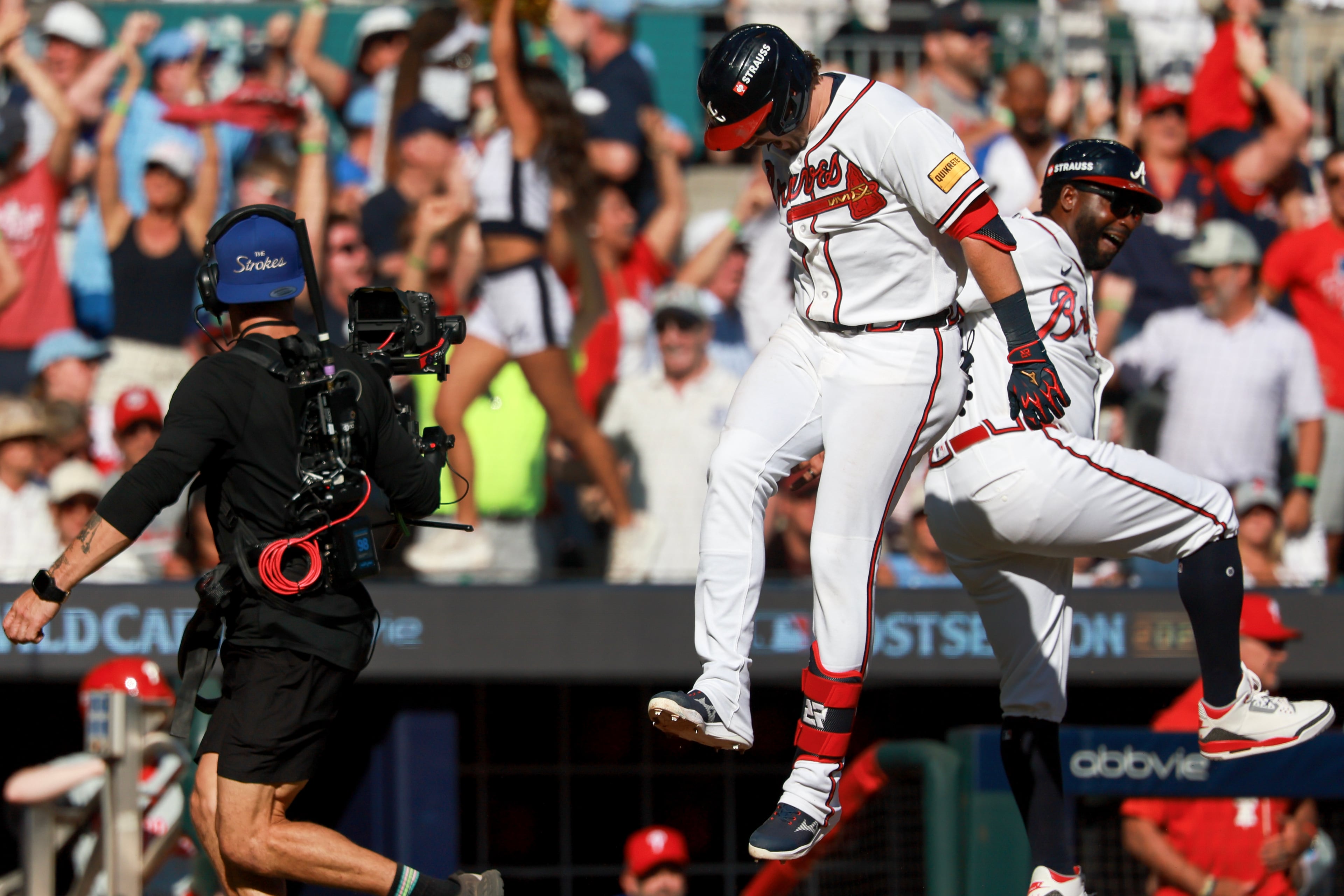 Atlanta Braves' Austin Riley racts with third base coach Tommy Watkins while rounding the bases after hitting a three-run home run against the Philadelphia Phillies during the eighth inning of Game 1 of a MLB National League Wild Card playoff series between the Atlanta Braves and the Philadelphia Phillies, Tuesday, Sept. 29, 2026, in Atlanta. (Jason Getz/AJC)