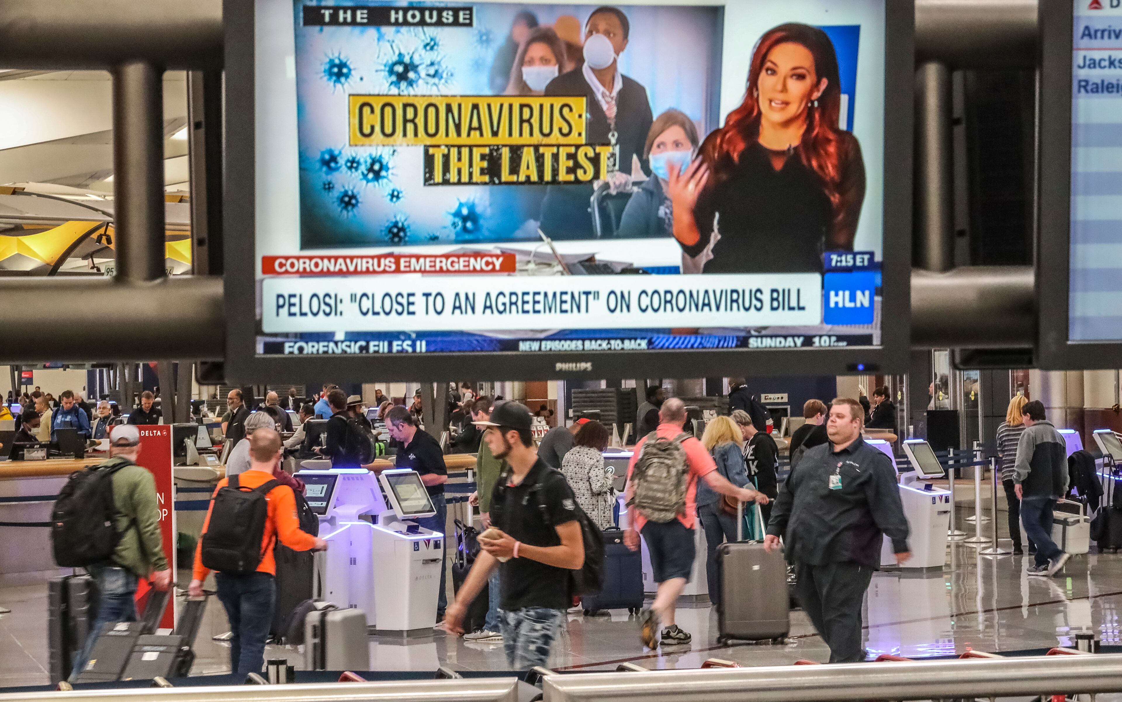 March 13, 2020 Hartsfield-Jackson International Airport: Travelers were framed using the kiosks at the Delta Airlines ticket counter under the broadcast news TV monitors featuring Coronavirus news at baggage claim at Hartsfield-Jackson International Airport on Friday, March 13, 2020. The Coronavirus pandemic is affecting everyone across the State of Georgia and Metro Atlanta. Everything from travel to everyday business. âÃúWe are expecting a 30 to 50% drop in the hospitality business over the next two months,âÃù said William Pate, chief executive of the Atlanta Convention and Visitors Bureau. As of Friday, there were 42 confirmed cases in Georgia with four people in Bartow, Charlton (1), Cherokee (2), Cobb (8), Coweta (1), DeKalb (5), Fayette (5), Floyd (1), Fulton (8), Gordon (2), Gwinnett (2), Lee (1), Lowndes (1) and Polk (1). JOHN SPINK/JSPINK@AJC.COM
