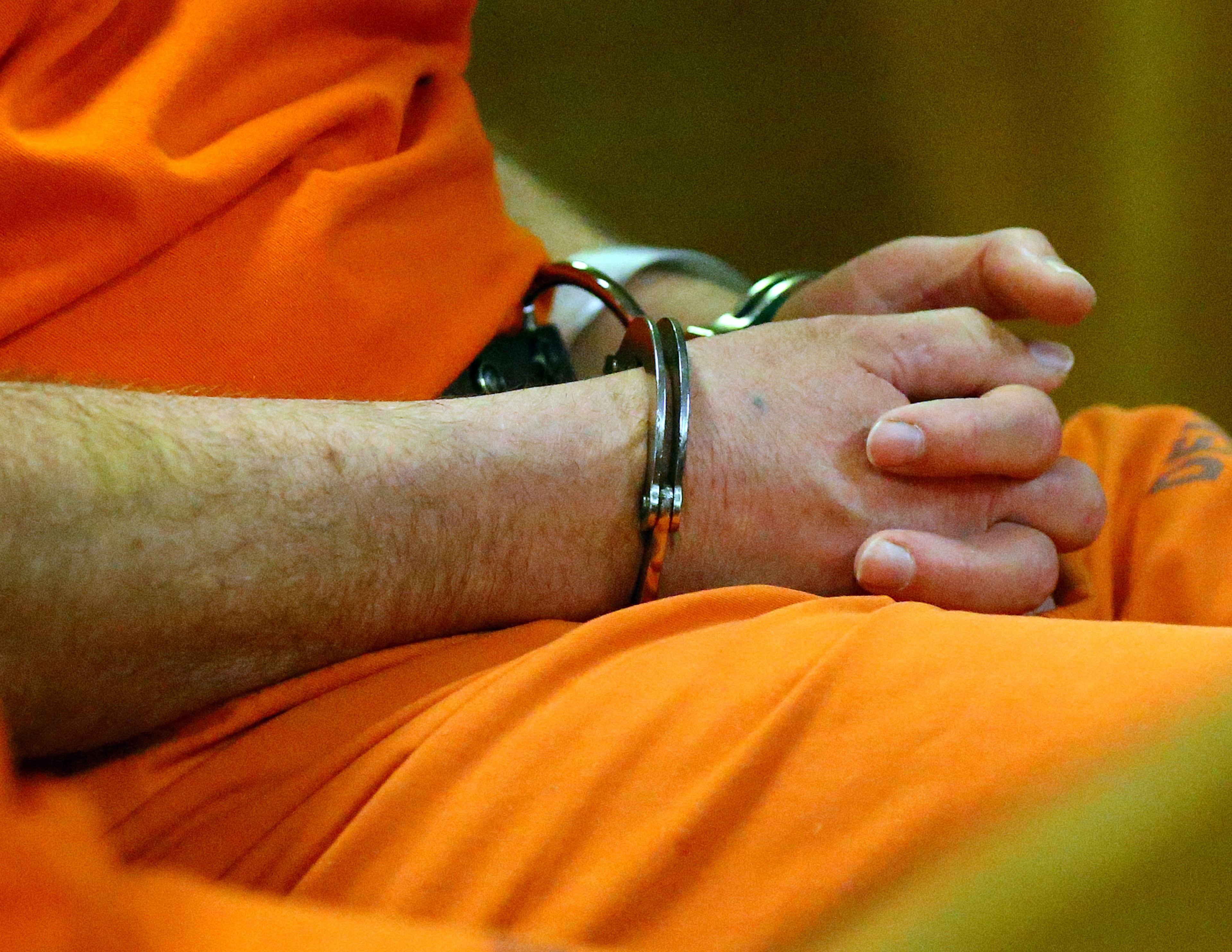 John McGill, principal of Mt. Carmel Elementary School in Douglas County, sits in handcuffs in the courtroom during his first appearance hearing at DeKalb County Magistrate Court for a felony offense of electronic pornography and child exploitation on Tuesday, March 4, 2014, in Decatur.