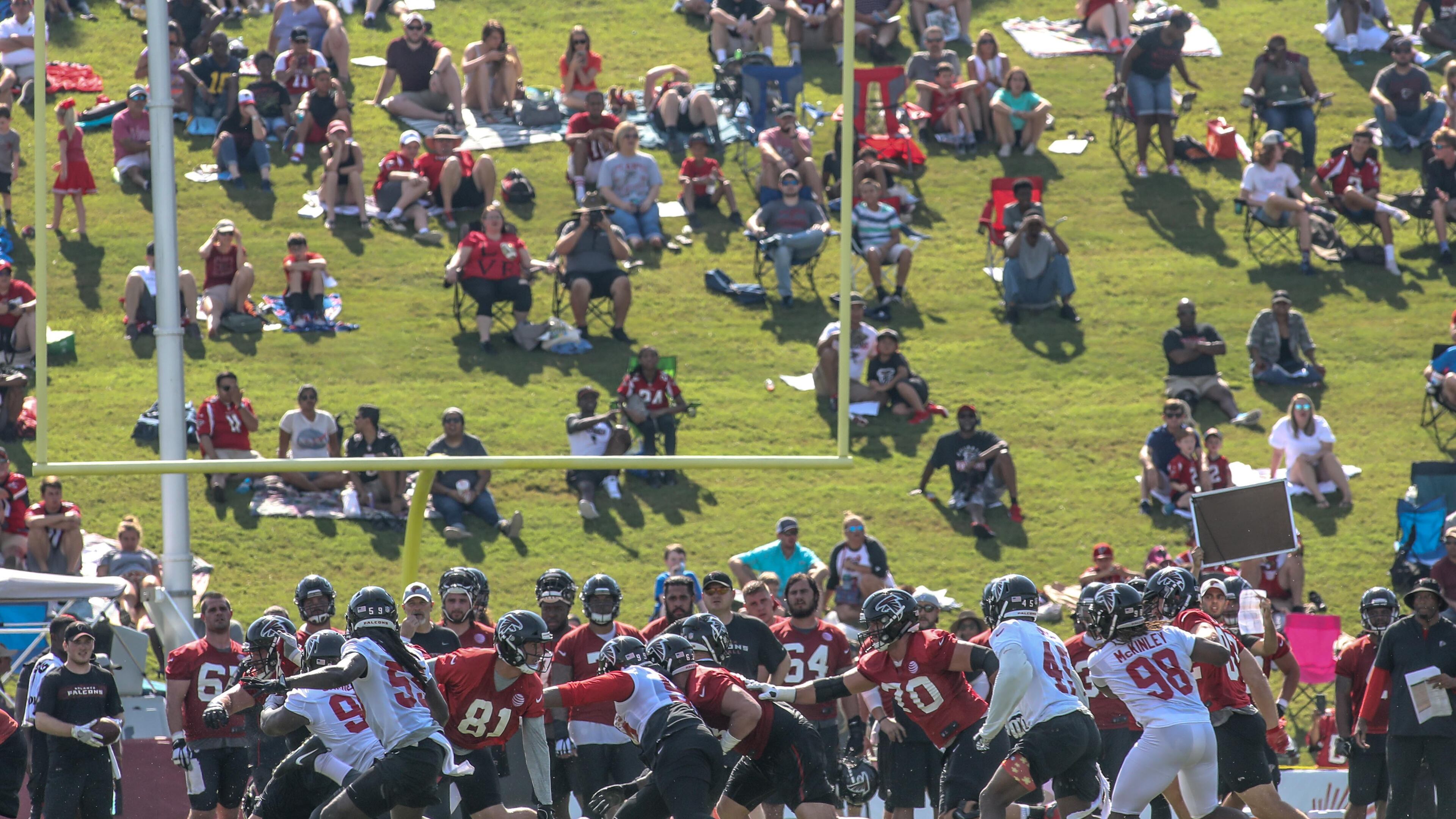 Fans watch the Atlanta Falcons during a play at training camp, Saturday, July 28, 2018, in Flowery Branch, Ga.