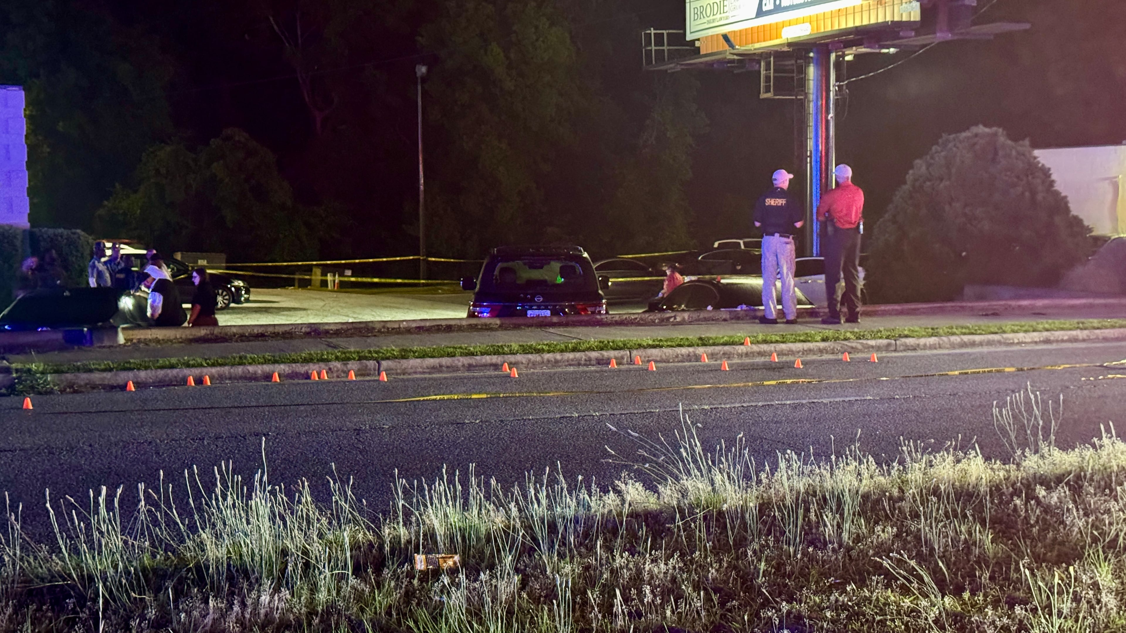 Orange markers placed by Bibb County sheriff's deputies show where some of the spent shell casings landed in the street outside a Macon bar where three people were shot to death and six others were wounded early Sunday. (Joe Kovac Jr. / AJC)