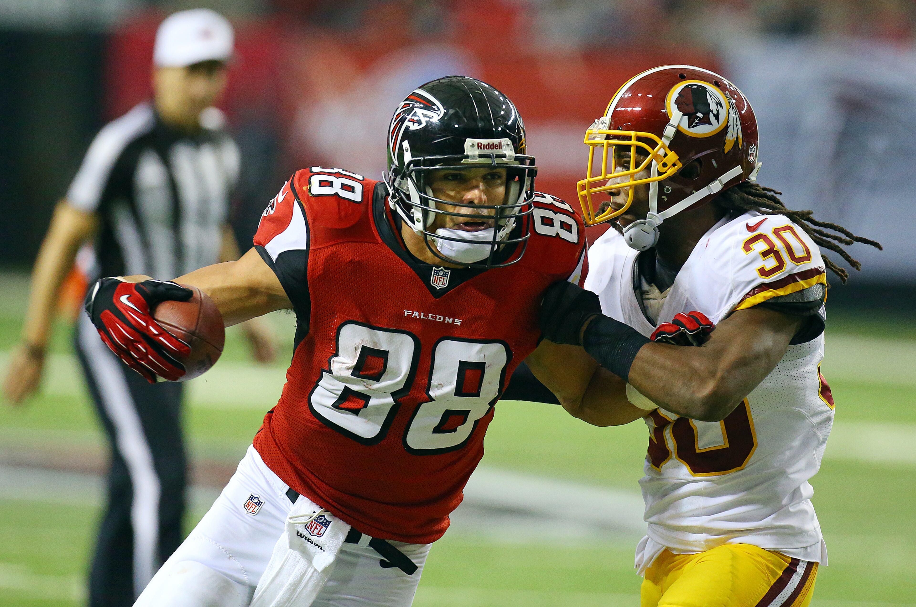Falcons tight end Tony Gonzalez becomes the 5th player in NFL history to reach 15,000 receiving yards catching a pass against Redskins cornerback E.J. Biggers during the second half of a NFL football game on Sunday, Dec. 15, 2013, in Atlanta.