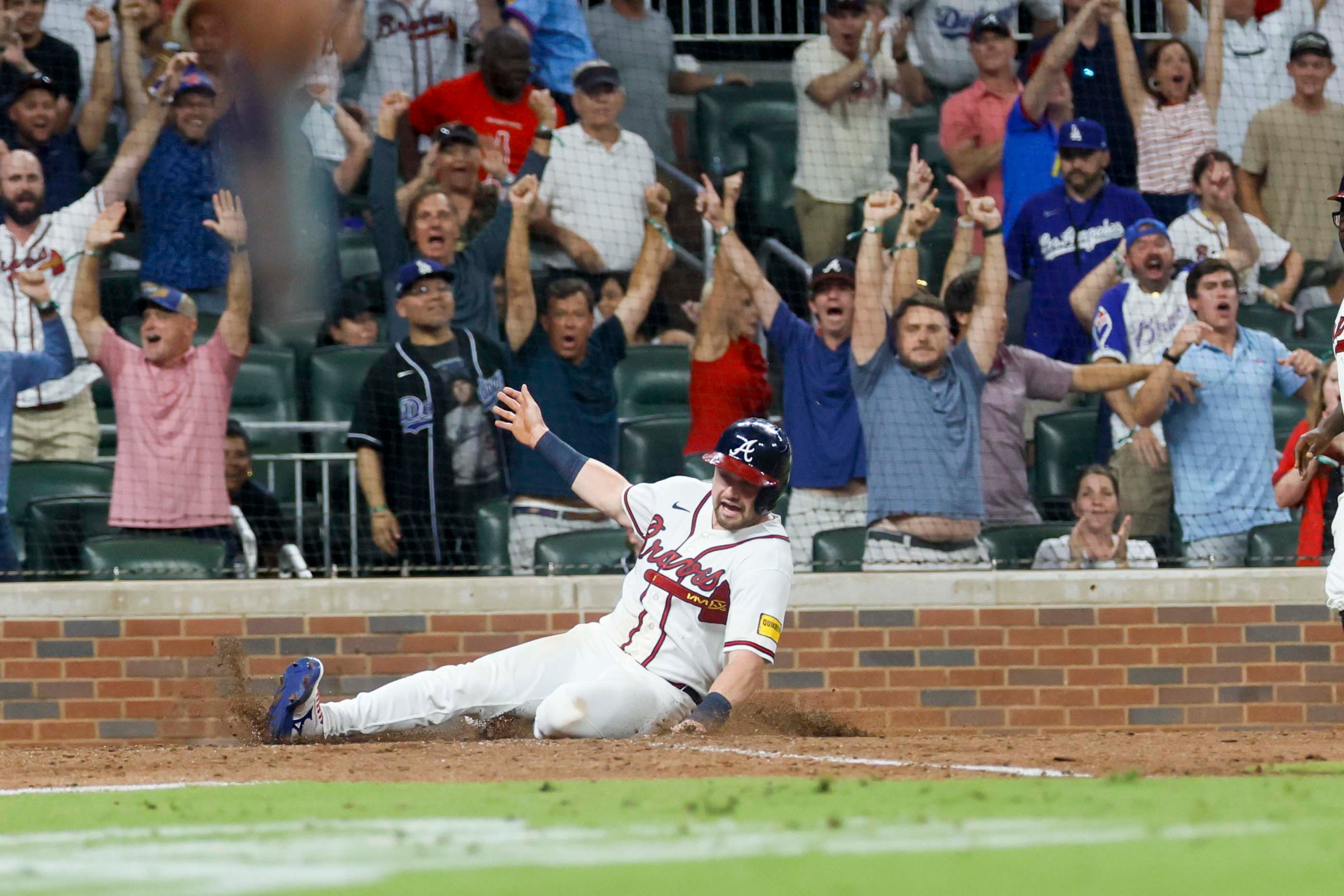 Braves left fielder Lane Thomas slides safely across home plate to win the game against the Los Angeles Dodgers on Wednesday, Aug. 26, 2026, at Truist Park in Atlanta. (Miguel Martinez/AJC)