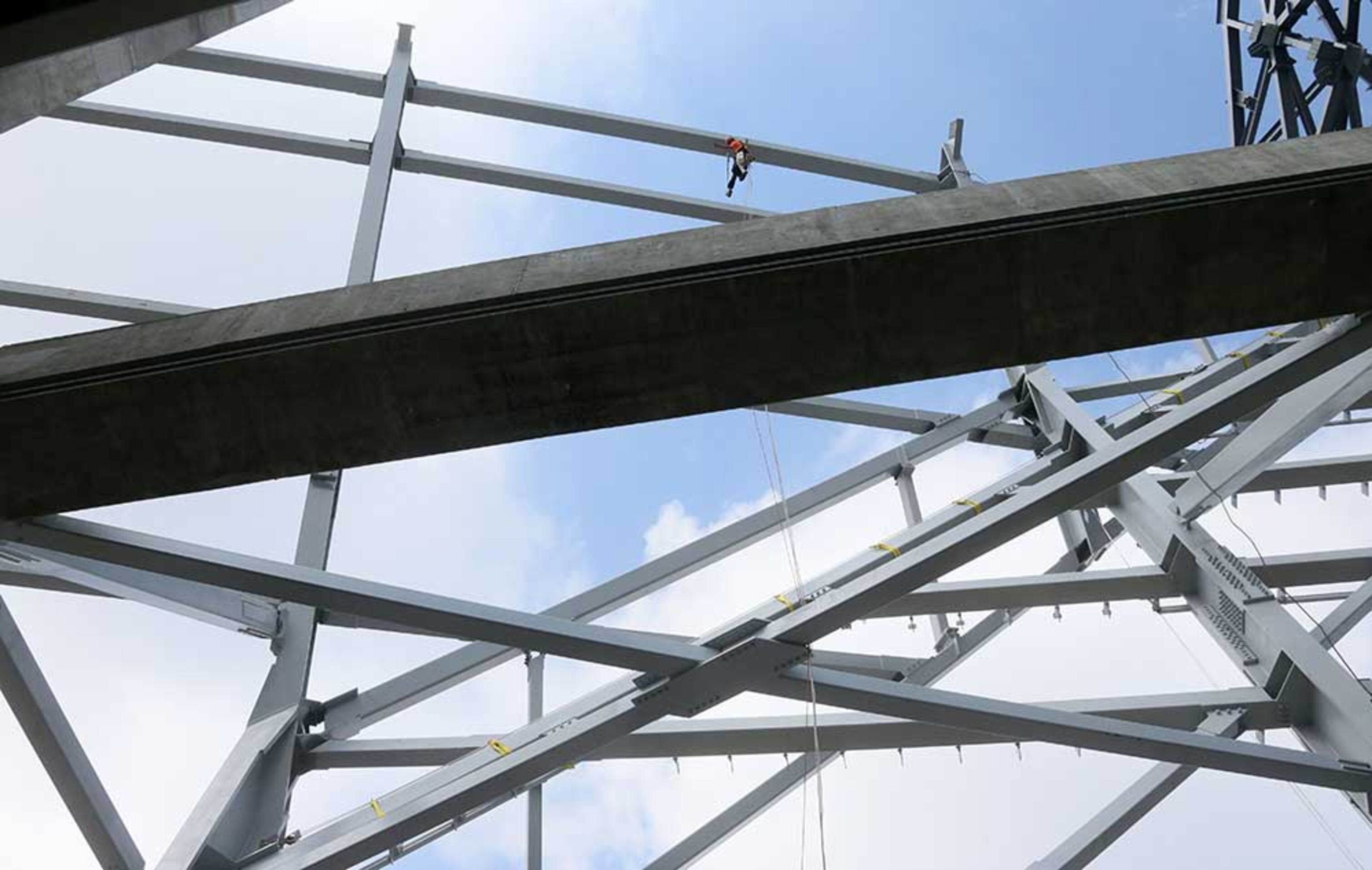 Looking outward from the upper concourse, erection of the facade steel is visible around the exterior of the stadium.