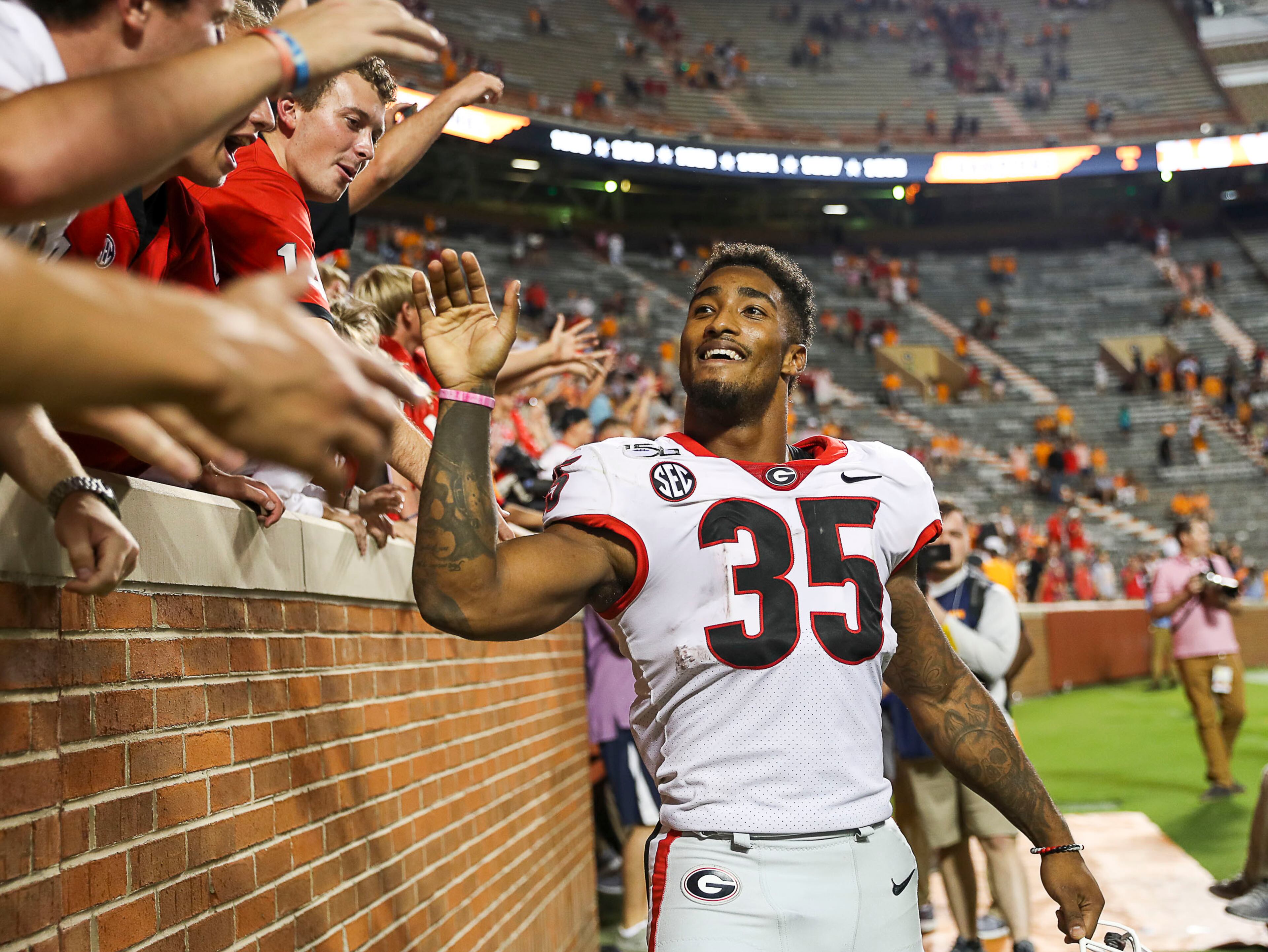 Georgia Bulldogs running back Brian Herrien (35) interacts with fans following a win over Tennessee. (Alyssa Pointer/Atlanta Journal Constitution)