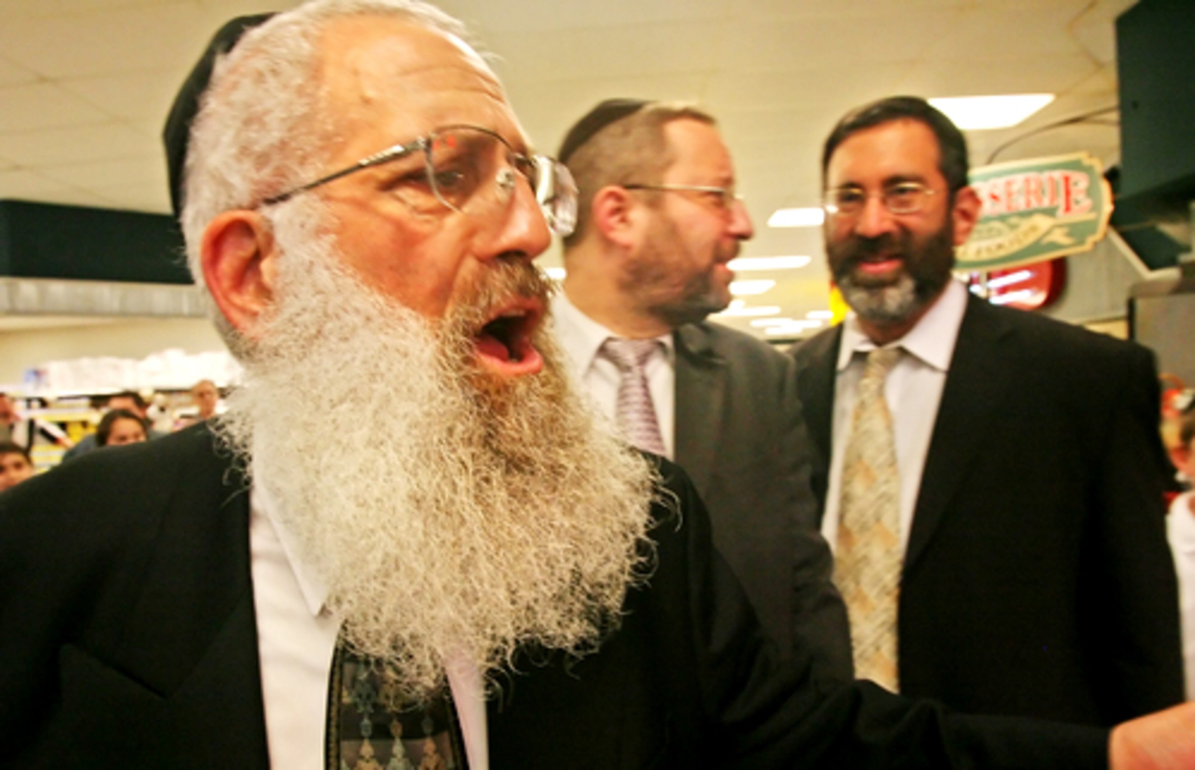 Rabbi Kalmen Rosenbaum, head of the Torah Day School in Atlanta, sings along during a Hanukkah celebration at the Toco Hills Kroger on Sunday. The children sang songs, danced and lit a Menorah.