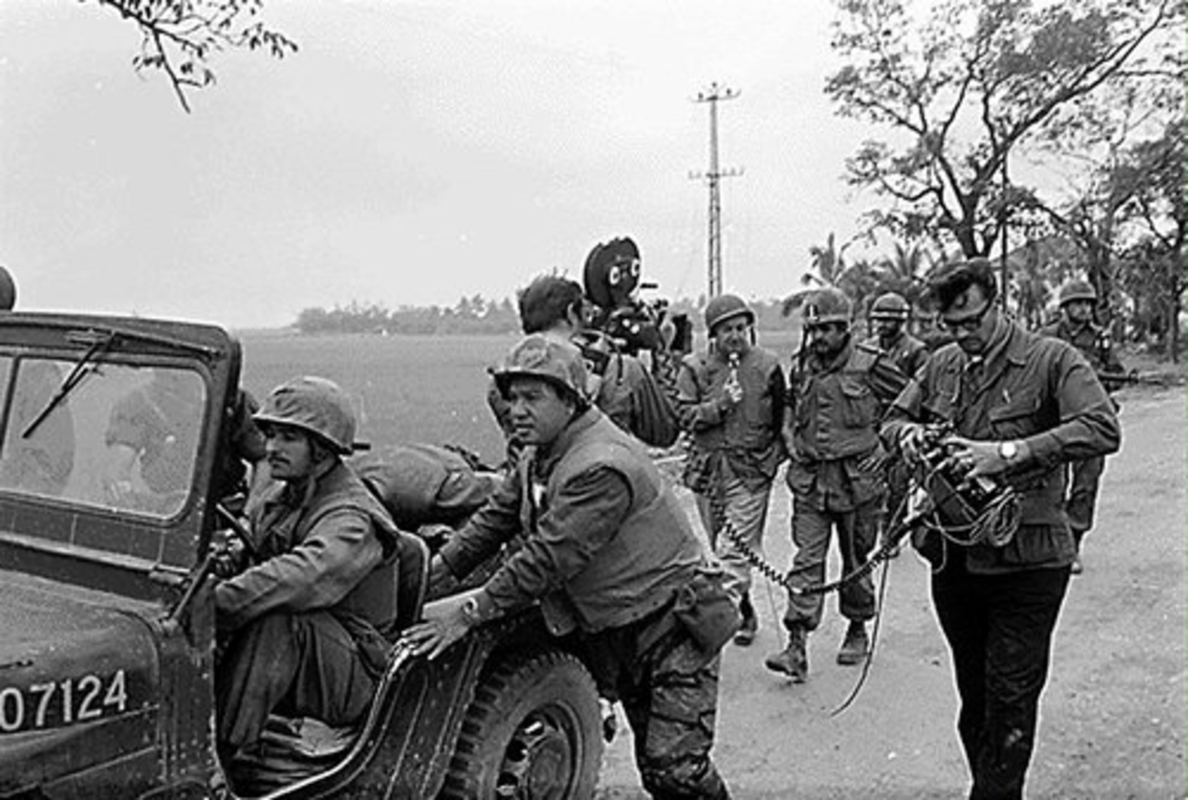 Walter Cronkite, holding microphone, and his crew use a jeep as a camera dolly during an interview with a Marine officer during the battle of Hue City, Vietnam, in 1968.