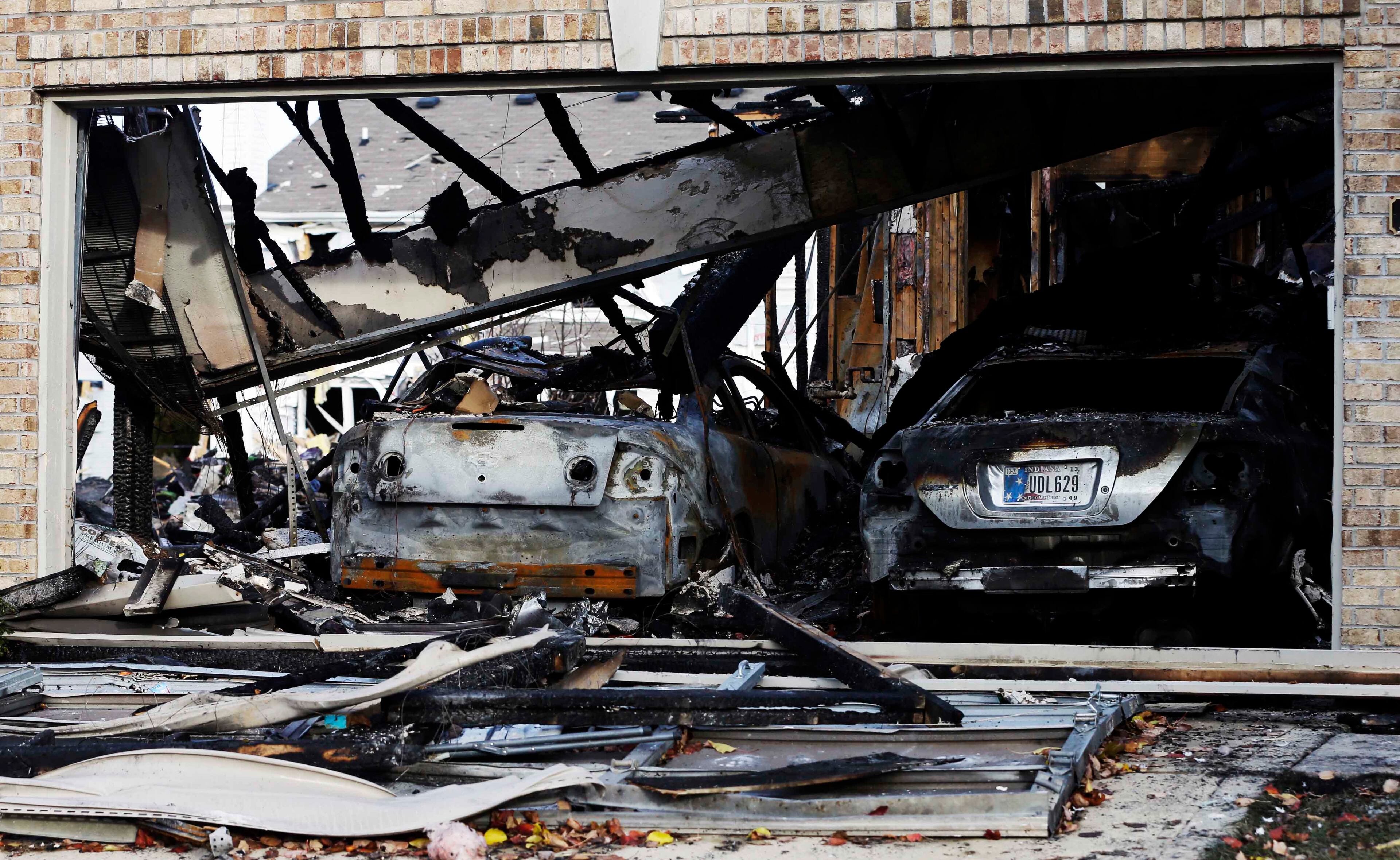 Two cars sit in a home that was heavily damaged by a explosion, Sunday in Indianapolis. Nearly three dozen homes were damaged or destroyed, and seven people were taken to a hospital with injuries, authorities said Sunday. The powerful nighttime blast shattered windows, crumpled walls and could be felt at least three miles away.