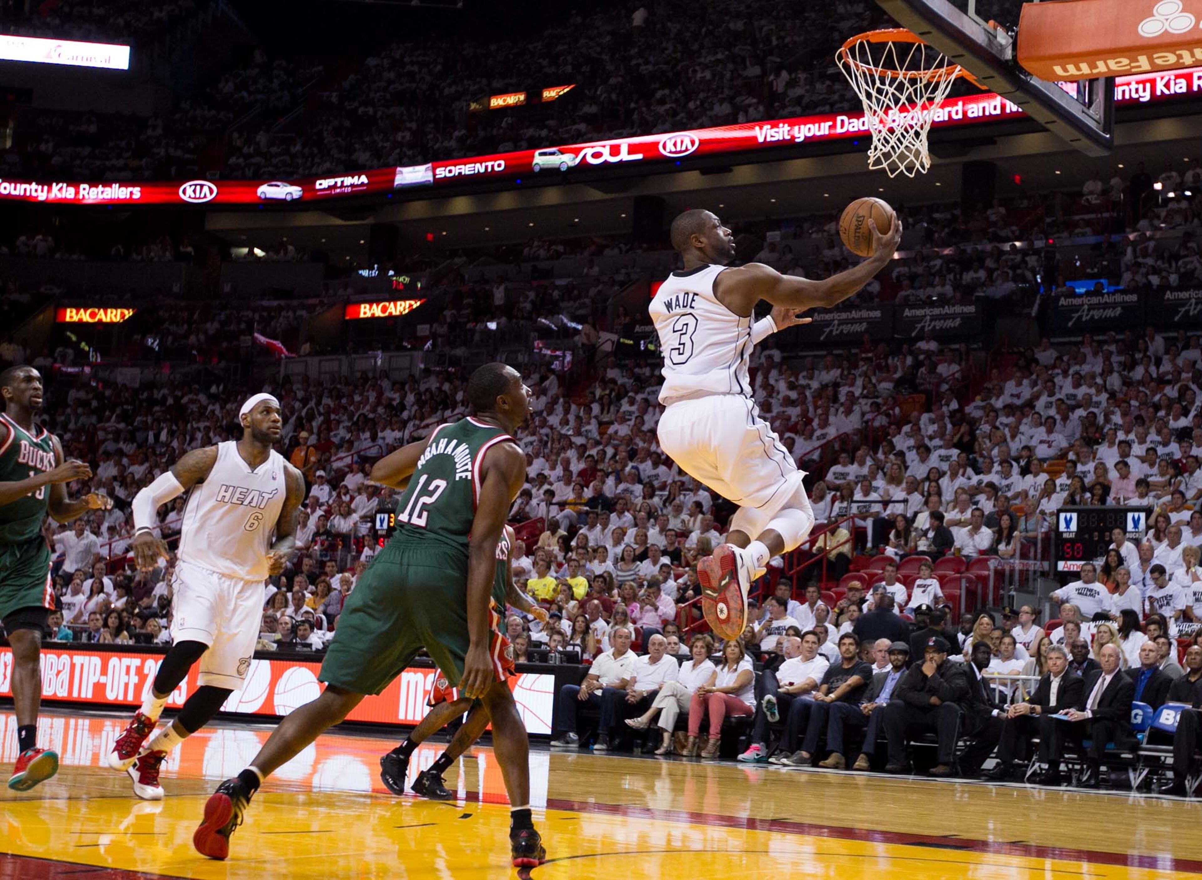 Miami Heat shooting guard Dwyane Wade (3) takes a pass from Miami Heat small forward LeBron James (6) for a layup in the second quarter as Milwaukee Bucks power forward Luc Richard Mbah a Moute (12) defends at AmericanAirlines Arena on April 21, 2013. (Allen Eyestone/The Palm Beach Post)