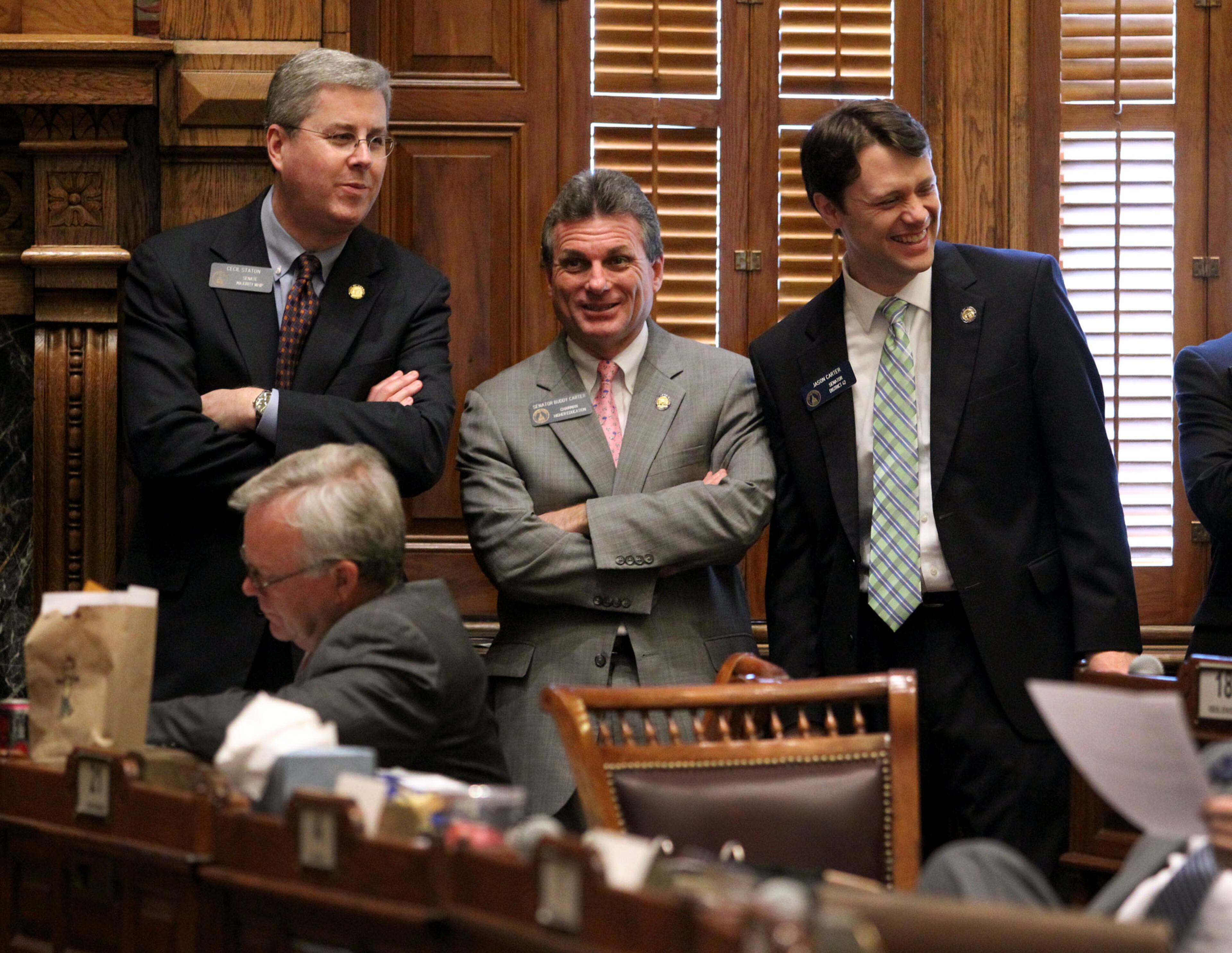 Sens. Cecil Staton, R-Macon, left, Buddy Carter, R-Pooler, and Jason Carter, D-Decatur, right, laugh during Legislative Day 13 in the Senate Chambers on Feb. 2, 2012.