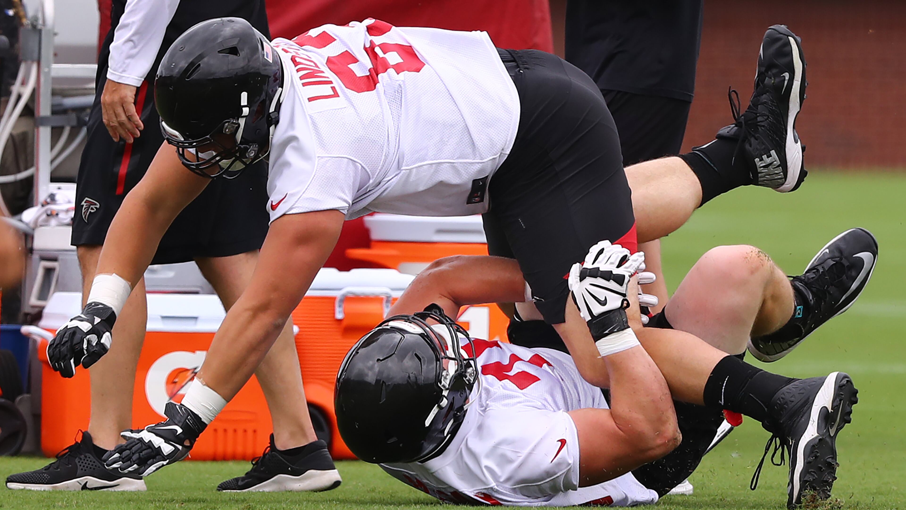 June 12, 2019 Flowery Branch: Atlanta Falcons first round draft picks offensive lineman Chris Lindstrom (top) and offensive tackle Kaleb McGary (bottom) get tangled up and wipe out while racing each other across the field to the next drill during minicamp on Wednesday, June 12, 2019, in Flowery Branch. Curtis Compton/ccompton@ajc.com