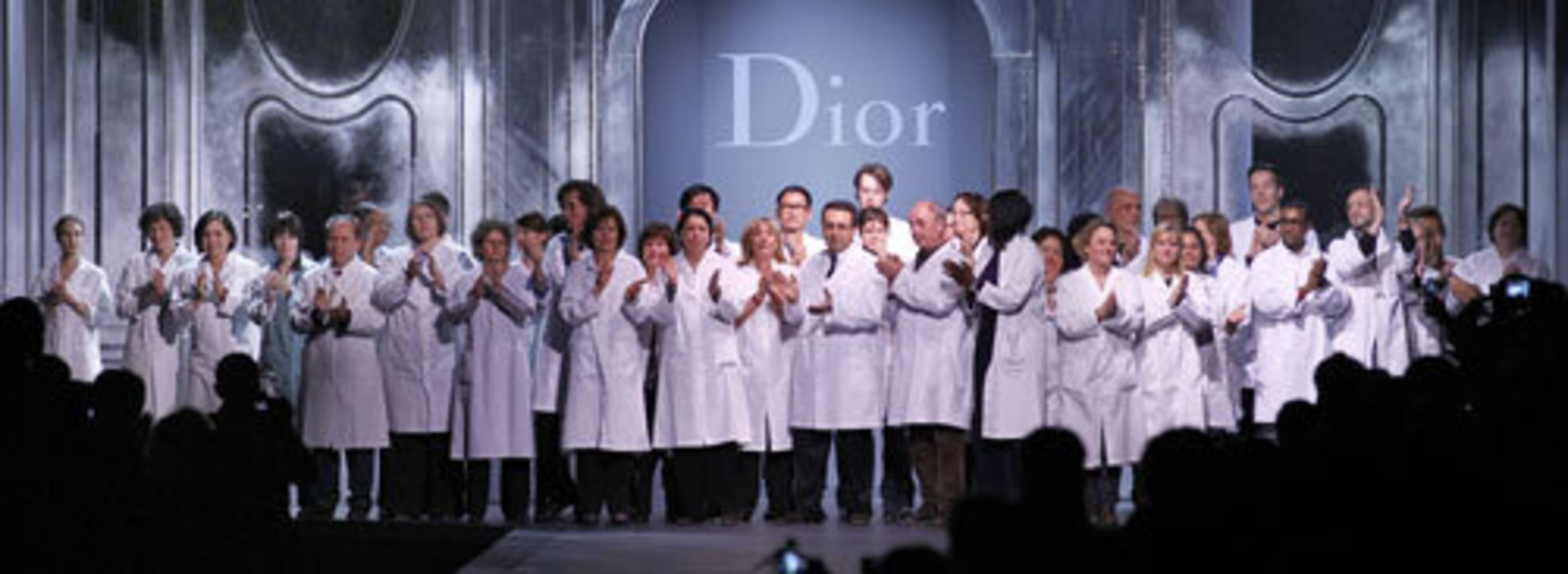 Dior fashion house employees acknowledge applause at the end of the presentation.