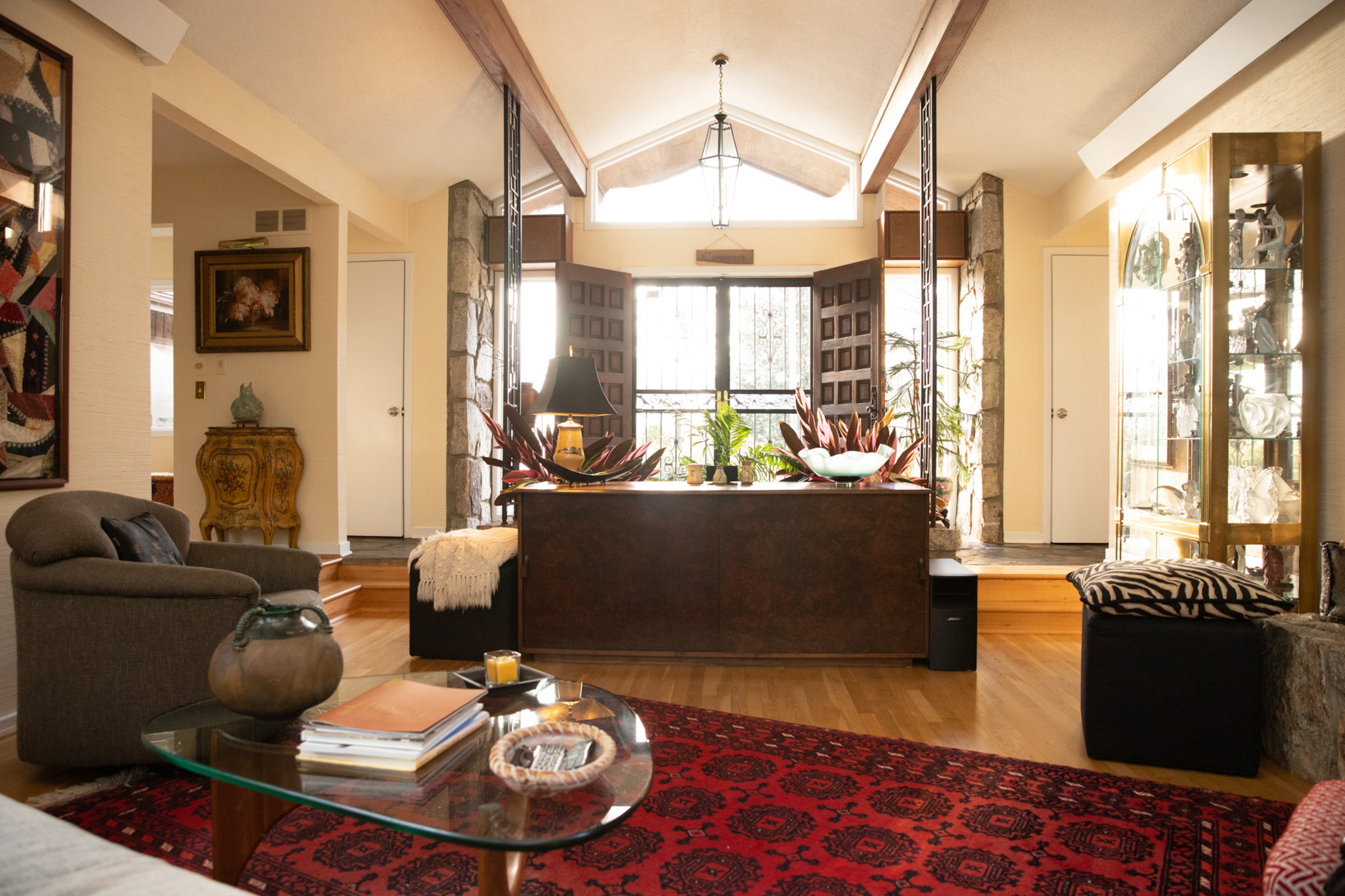 When the house was first built, Jan Heck planned to put two wooden beams in the ceiling that would extend from the backyard, go all the way through the living room, and come out to the front of the house. The wood was so long that they needed additional support in the form of two wrought iron panels. These panels were placed on either side of the planter, and extend from the floor into the wooden beams. Text by Megan Wahn/Photo by Reynolds Rogers