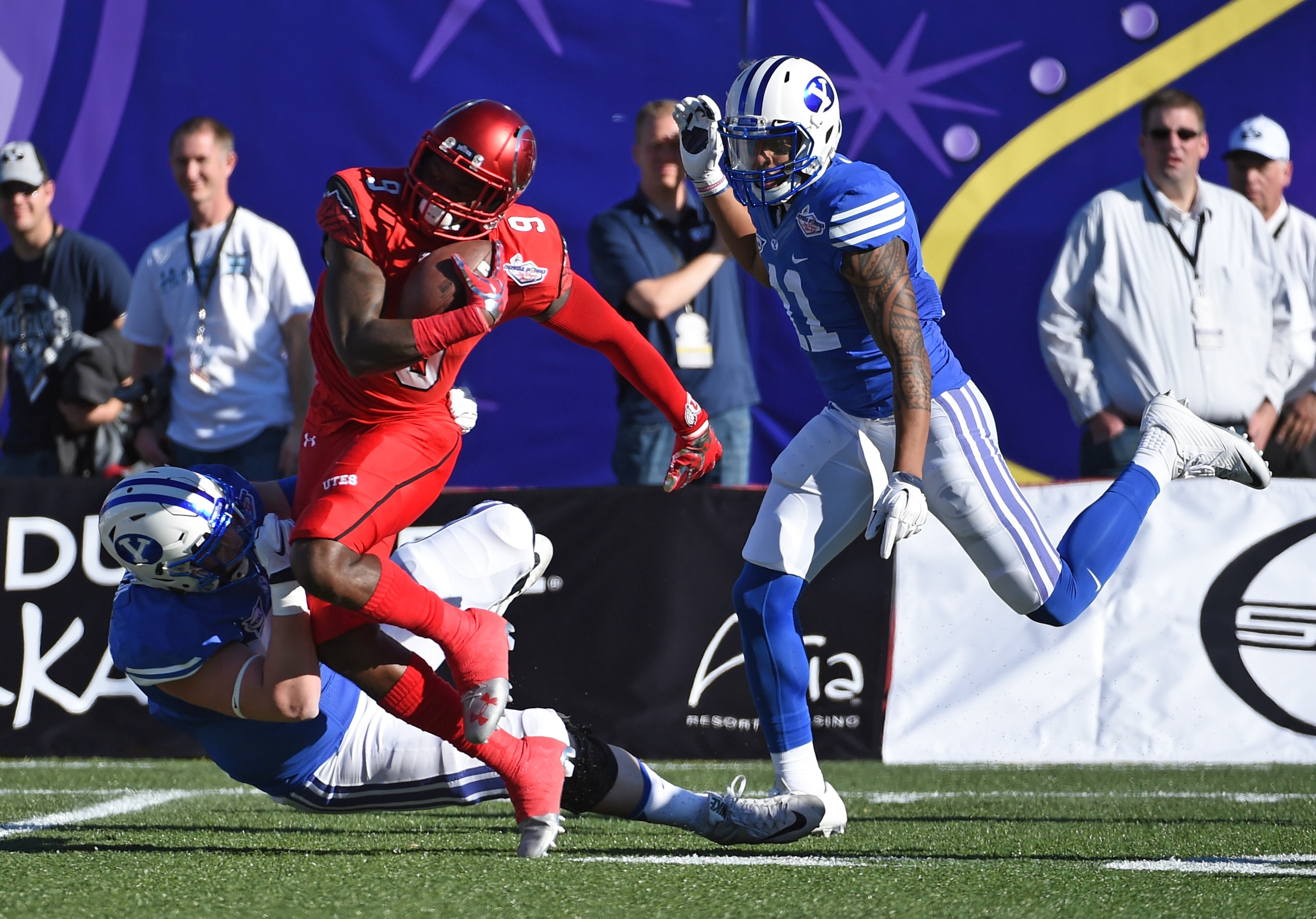 LAS VEGAS, NV - DECEMBER 19: Defensive back Tevin Carter #9 of the Utah Utes runs for yardage against offensive lineman Brad Wilcox #75 and wide receiver Terenn Houk #11 of the Brigham Young Cougars after Carter made his second interception of the game during the Royal Purple Las Vegas Bowl at Sam Boyd Stadium on December 19, 2015 in Las Vegas, Nevada. (Photo by Ethan Miller/Getty Images)