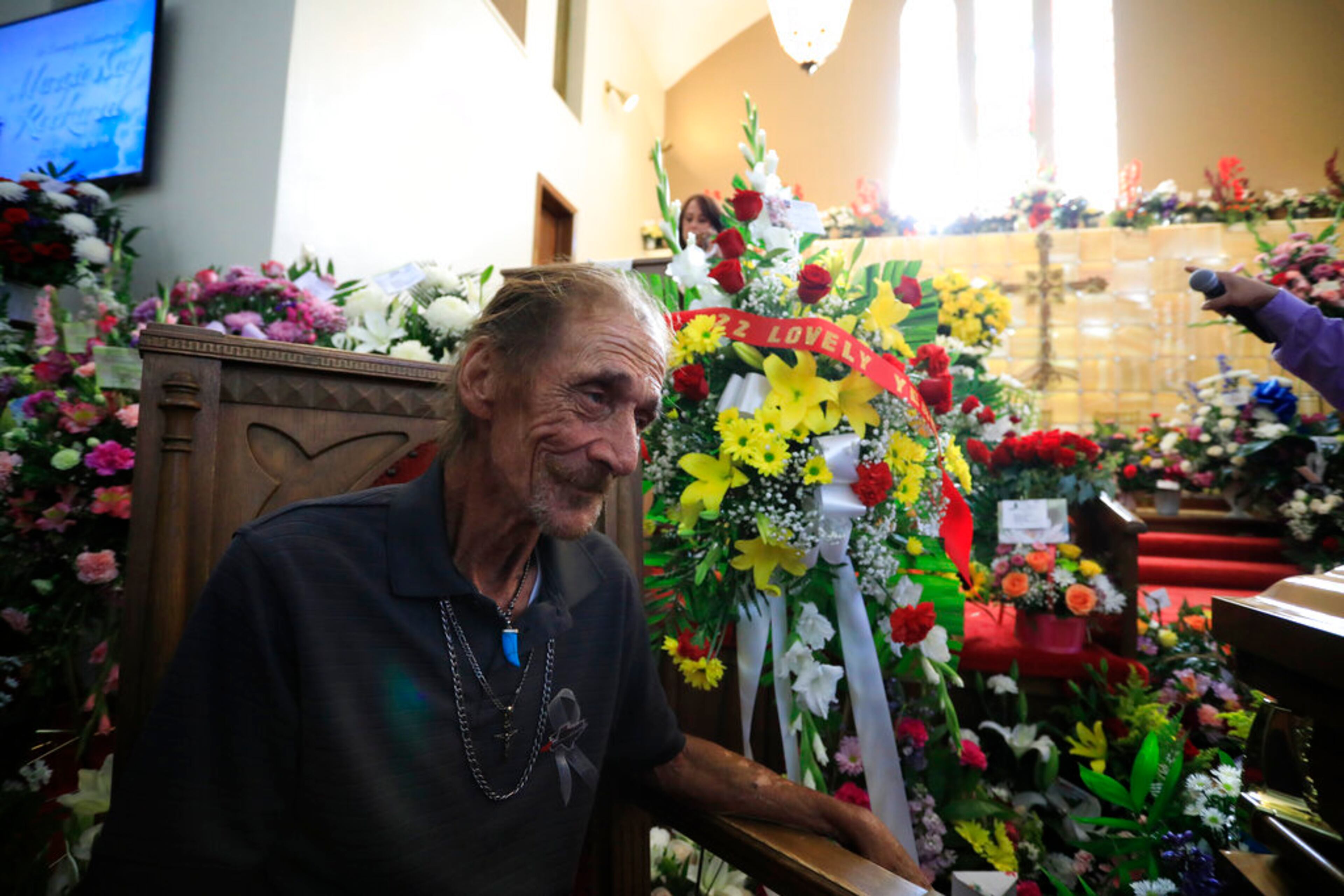 Antonio Basco, companion of Margie Reckard, sits next to a wreath honoring her during her funeral at La Paz Faith Memorial & Spiritual Center, Friday, Aug. 16, 2019, in El Paso, Texas. Reckard was killed during the mass shooting on Aug. 3. (AP Photo/Jorge Salgado)