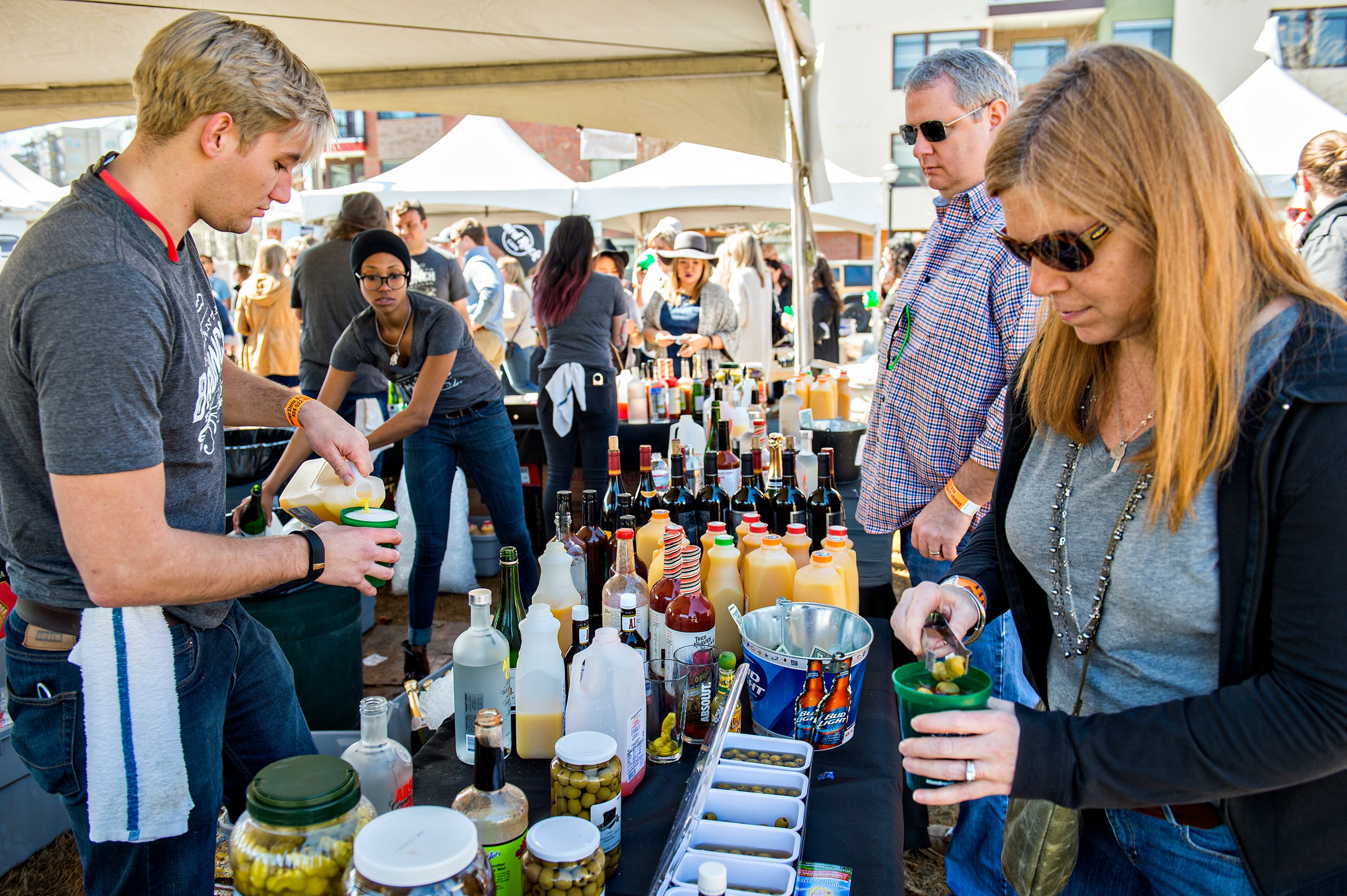 Heidi Russell (right) drops olives in her bloody mary as Chase Lovin (left) makes a drink for her husband, Geoff, during the Atlanta Brunch Festival at Fourth Ward Park in Atlanta on Saturday, March 5, 2016. JONATHAN PHILLIPS / SPECIAL