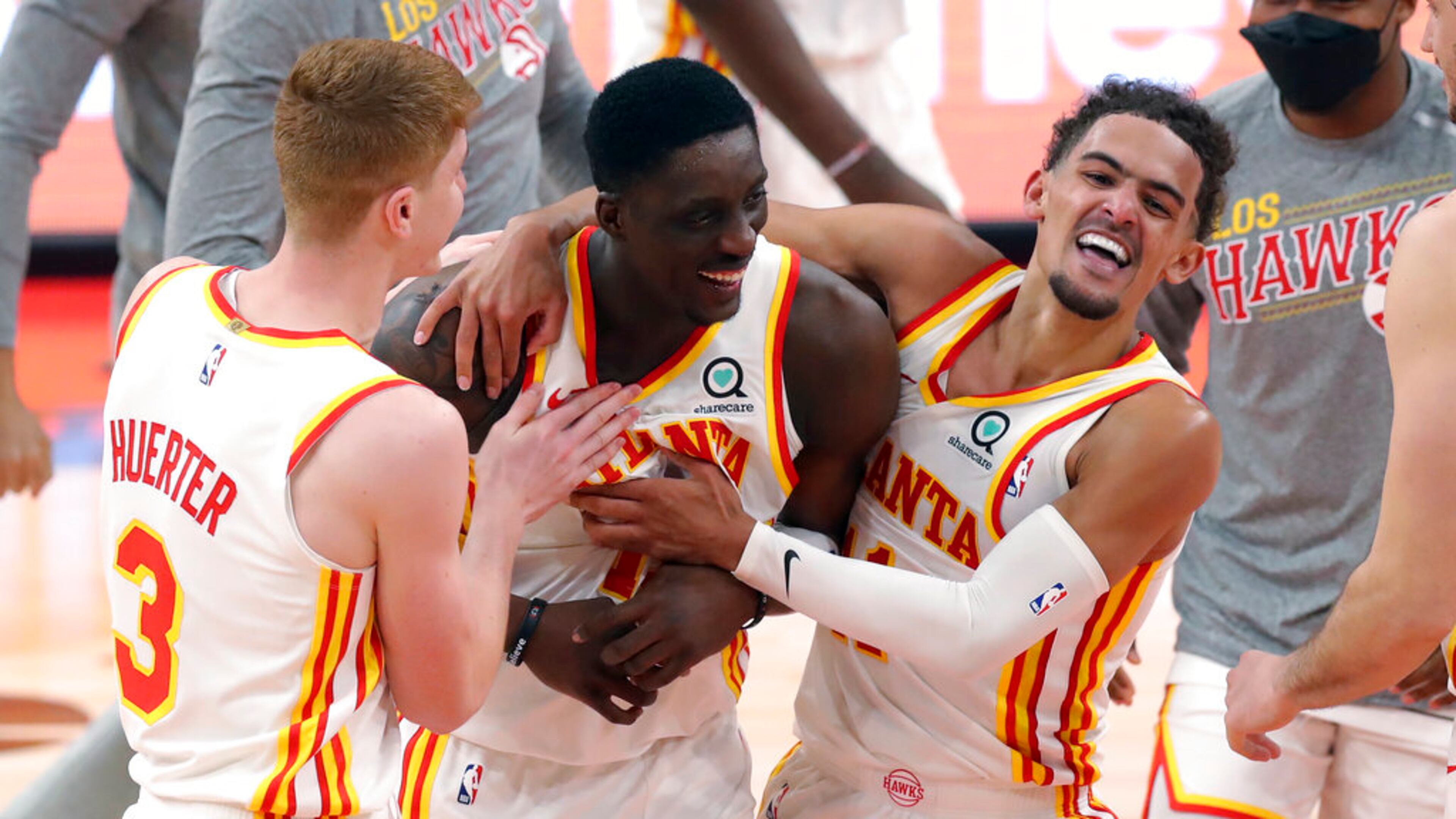 Atlanta Hawks' Tony Snell, center, is congratulated by Kevin Huerter (3) and Trae Young after his basket at the buzzer that gave the team a 121-120 win over the Toronto Raptors in an NBA basketball game Thursday, March 11, 2021, in Tampa, Fla. (AP Photo/Mike Carlson)