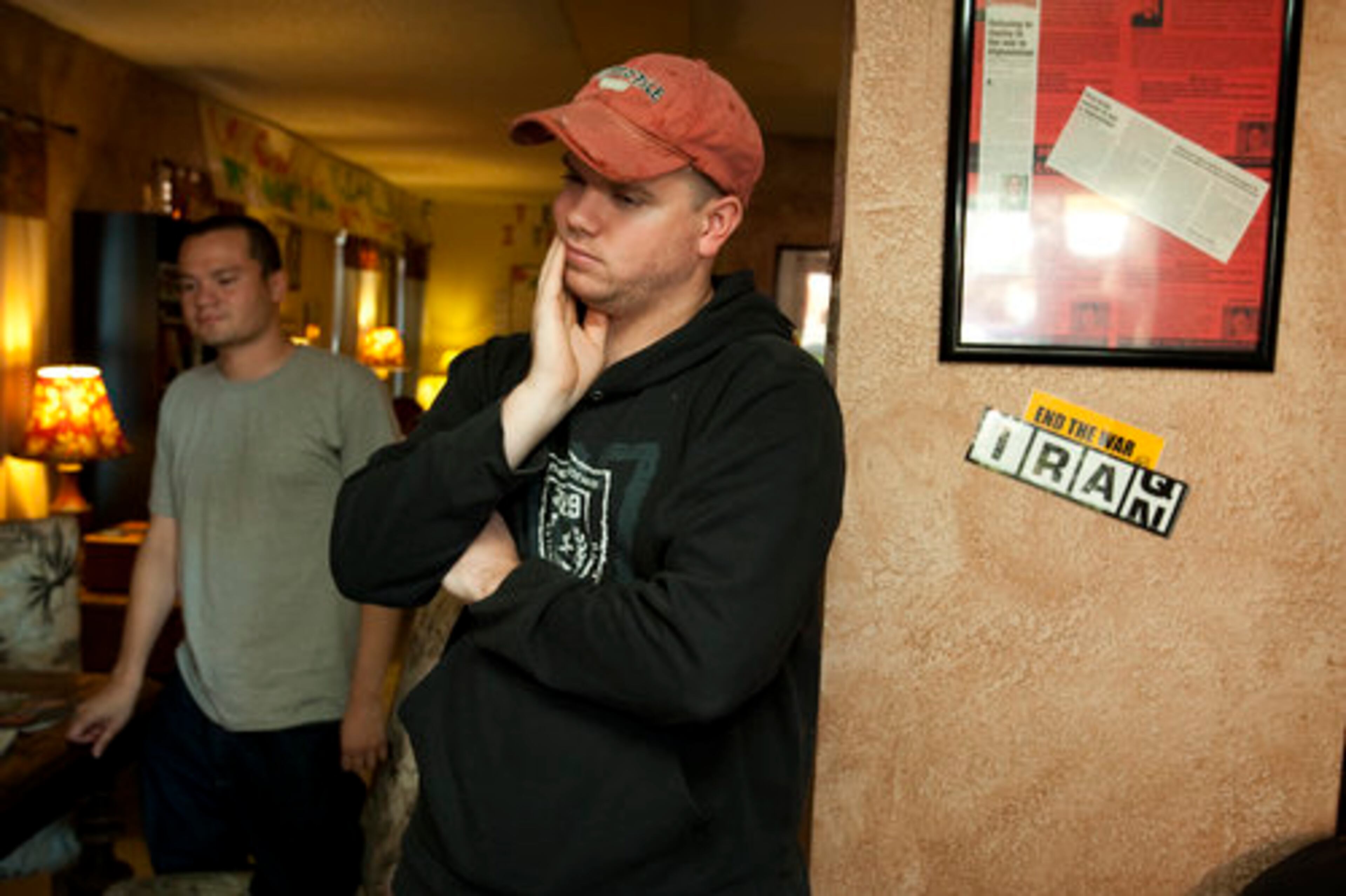 Former Army soldiers Victor Agosto (left) and Jeremy Hamilton watch the news about Fort Hood at Under the Hood, a gathering place frequented by soldiers in Killeen, Texas.
