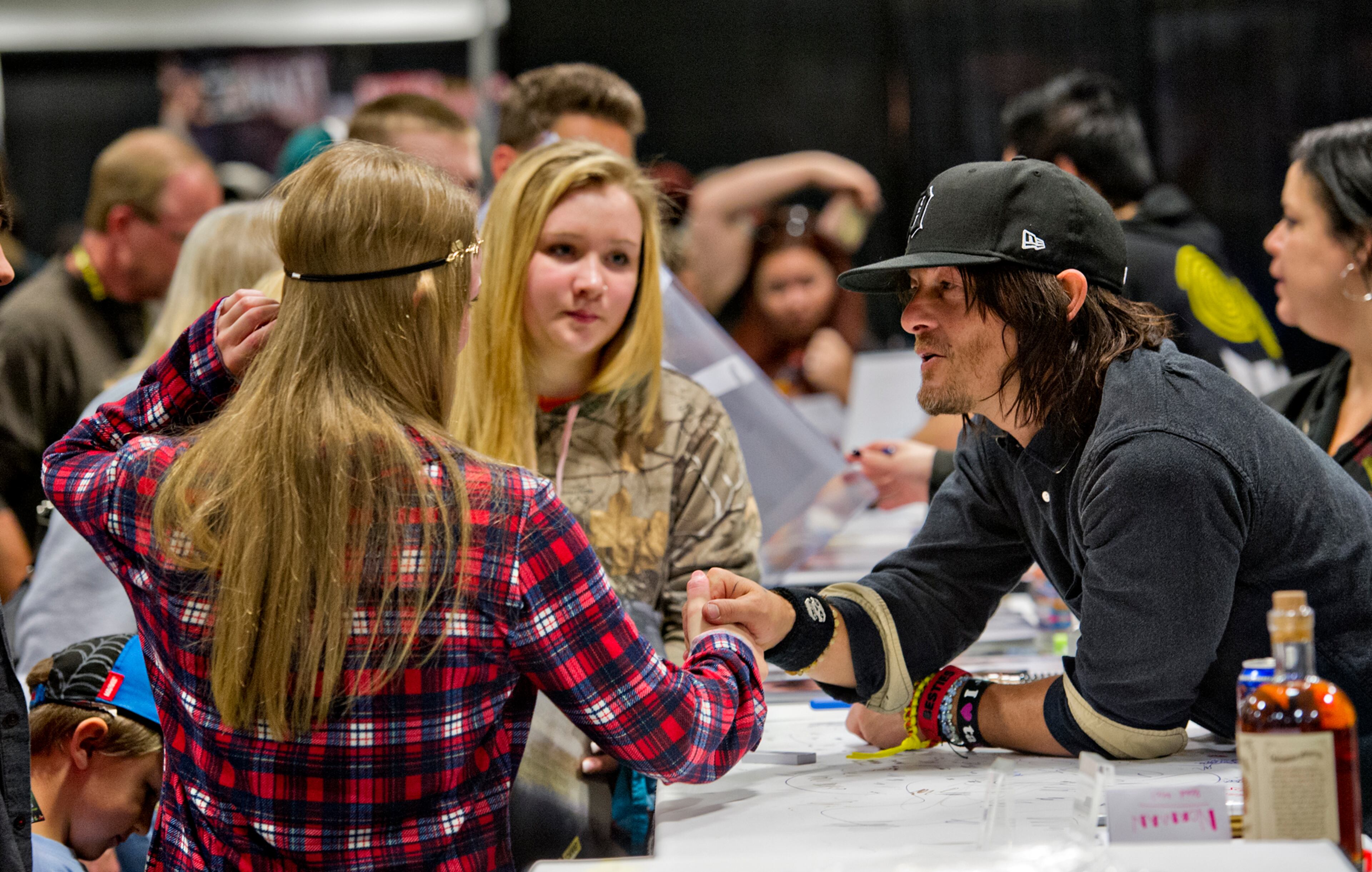 Norman Reedus, who plays Daryl Dixon on the Walking Dead, talks to Amanda Beffre and her sister Becca as he signs autographs during Walker Stalker Con in Atlanta. JONATHAN PHILLIPS / SPECIAL