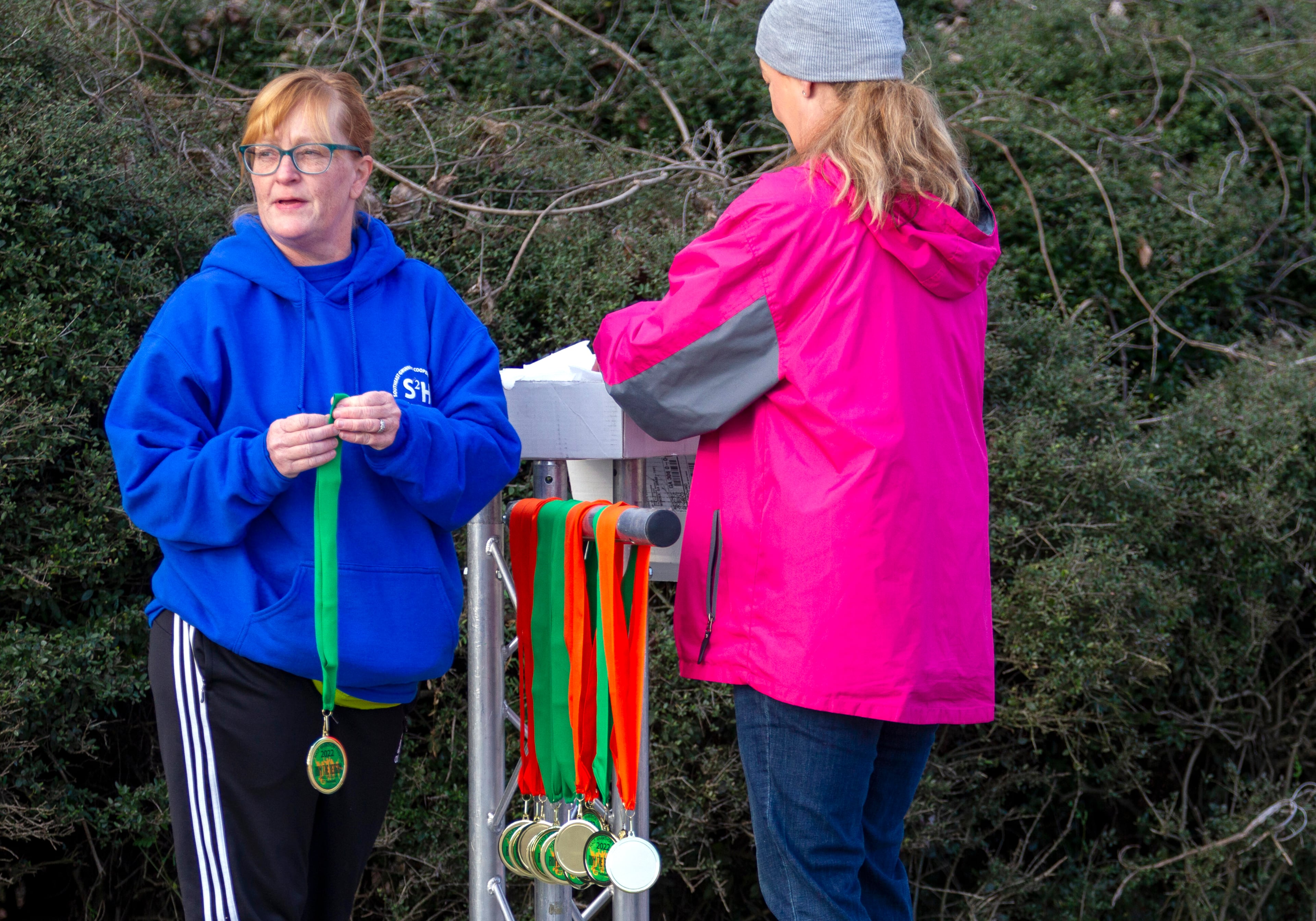 Tonya Hagan (left) and Amanda Soesbe organize the half-marathon finishers' medals before the start of the Run the Reagan race on Ronald Reagan Parkway in Gwinnett County on Saturday, February 26, 2022. (Photo: Steve Schaefer for The Atlanta Journal-Constitution)