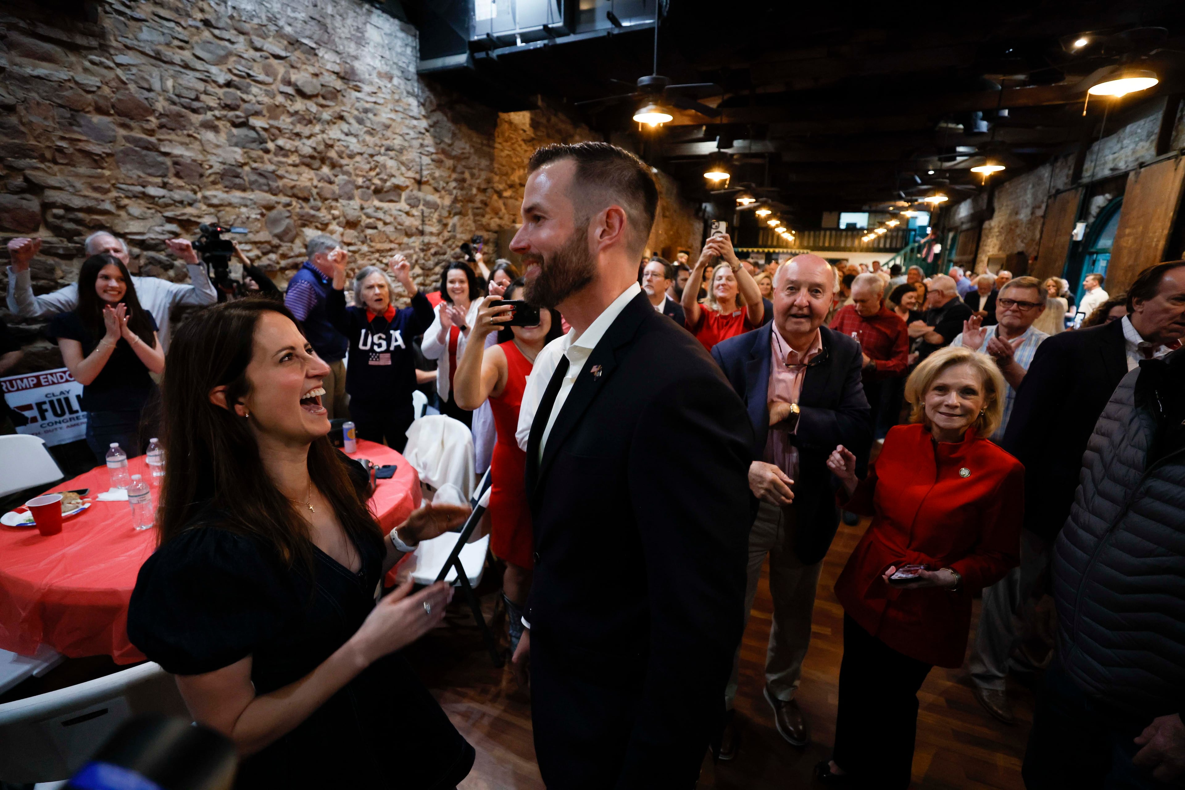 Kate Fuller reacts with her husband, Clay Fuller, as supporters cheer after his victory in the runoff election during Clay Fuller’s watch party at the Historic Ringgold Depot on Tuesday, April 7, 2026. Clay Fuller, a Republican who supports President Trump, won the special runoff election against Democrat Shawn Harris to replace Marjorie Taylor Greene in Georgia’s 14th Congressional District. (Miguel Martinez/AJC)