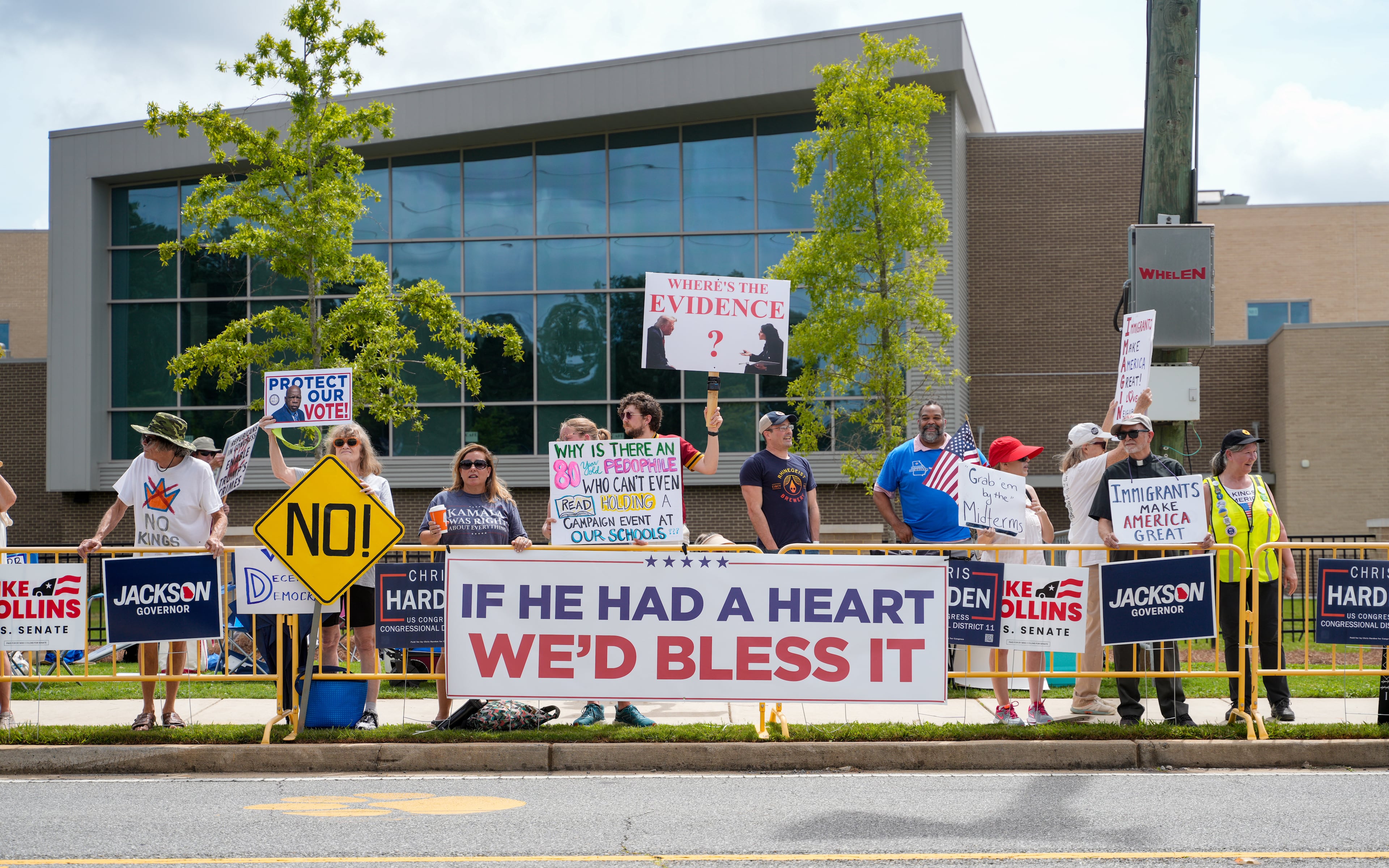 Protestors gather in Marietta while waiting for President Donald Trump to speak at Wheeler High School on Wednesday. (Ben Hendren for the AJC)