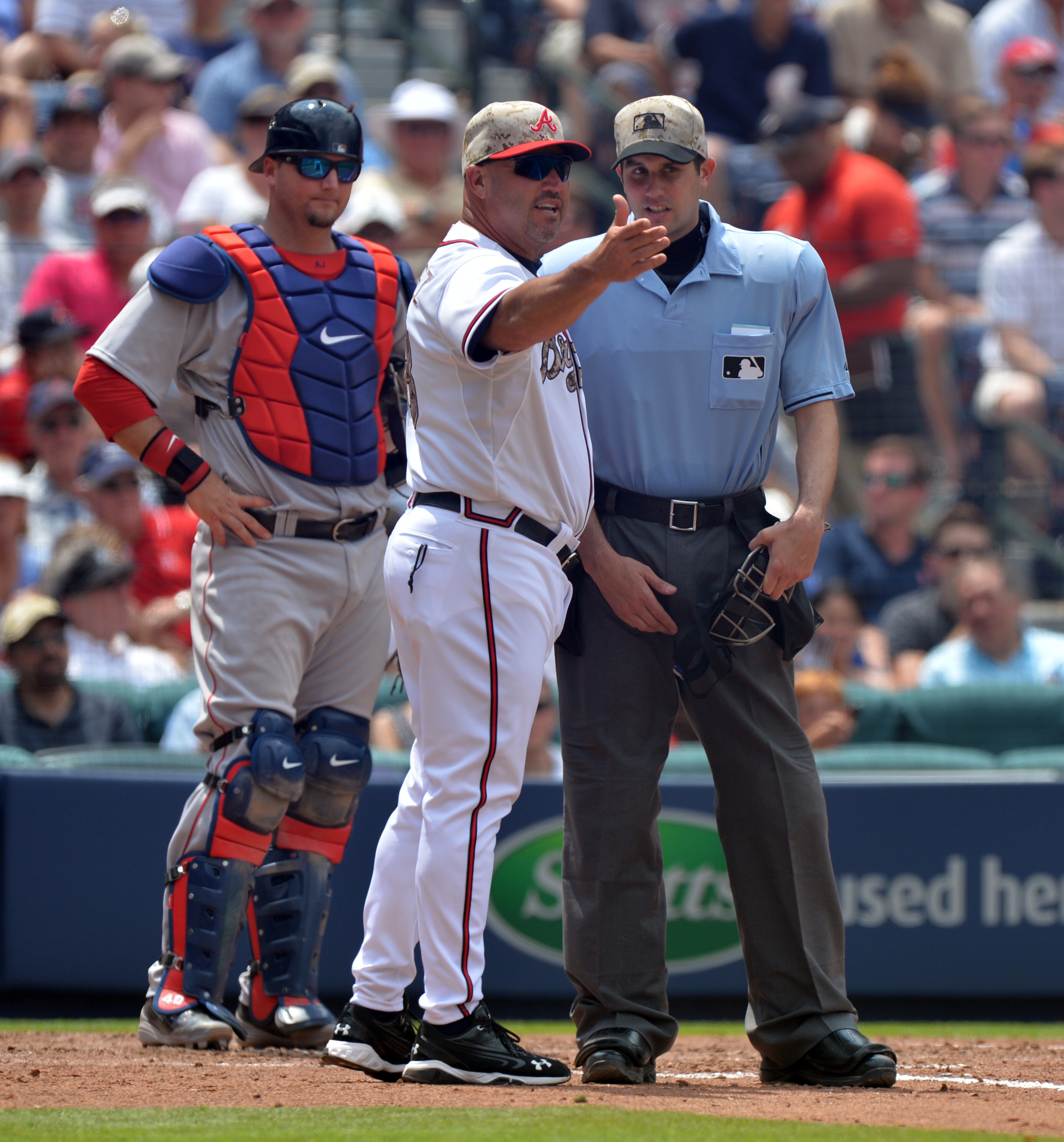Atlanta Braves manager Fredi Gonzalez argues a call with home plate umpire John Tumpane as Red Sox catcher A.J. Pierzynski looks on. Gonzalez was arguing after Ramiro was called out after bunting a running into the ball. BRANT SANDERLIN /BSANDERLIN@AJC.COM