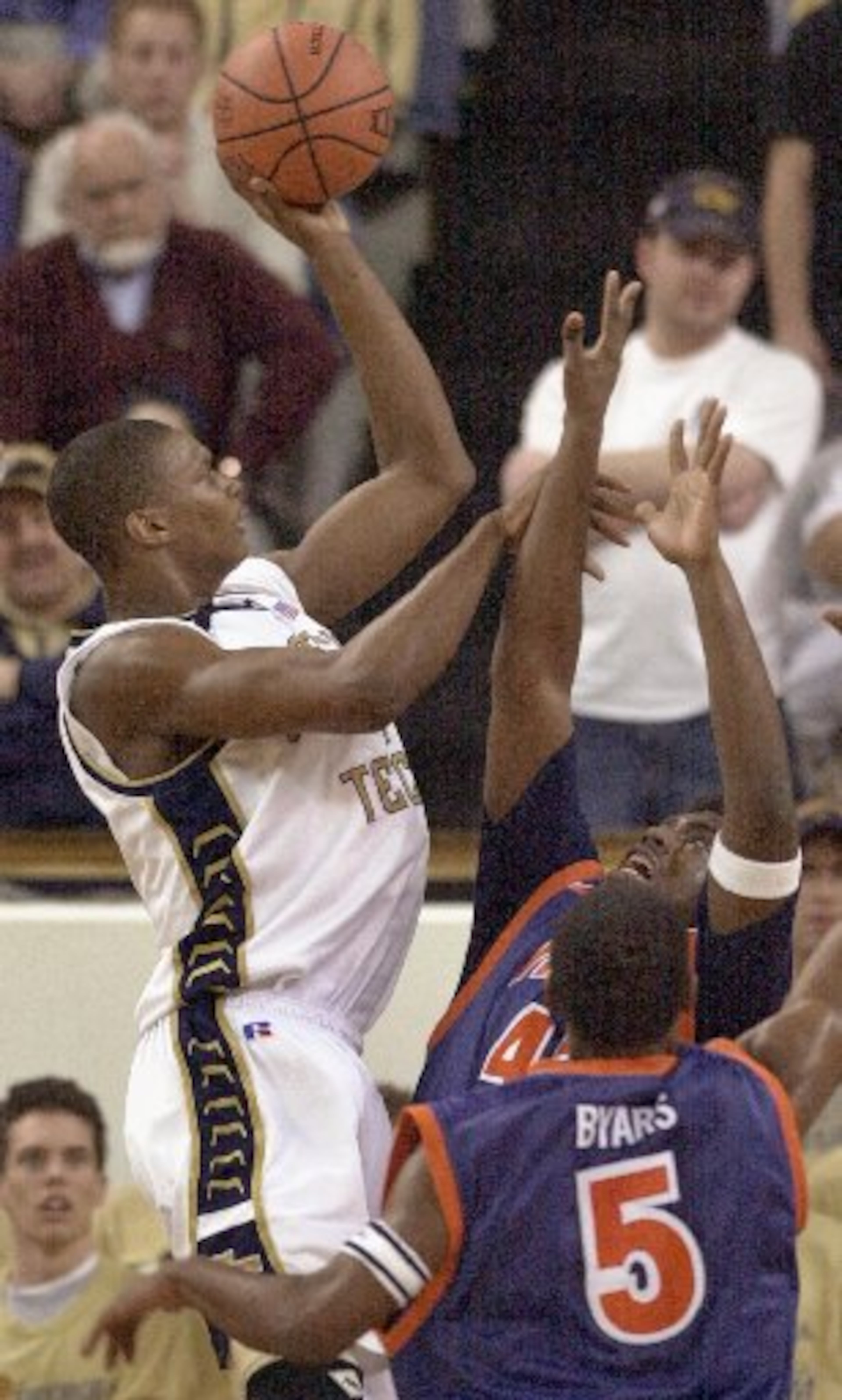 Georgia Tech forward Chris Bosh, left, takes a shot over Virginia defenders Derrick Byars (5) and Elton Brown during the first half Saturday, Feb. 1, 2003, at Alexander Memorial Coliseum in Atlanta.