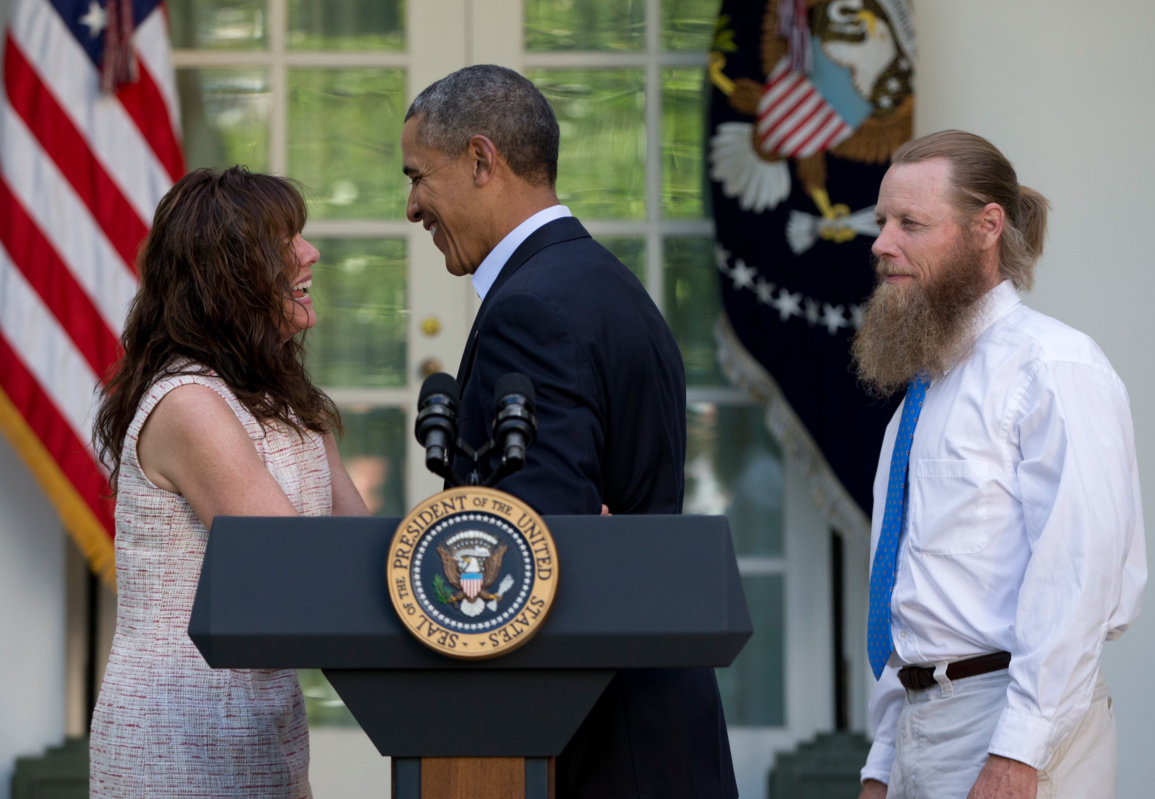 President Barack Obama smiles with Jani Bergdahl, as Bob Bergdahl stands at right, during a news conference in the Rose Garden of the White House in Washington on Saturday, May 31, 2014 about the release of their son, U.S. Army Sgt. Bowe Bergdahl. Bergdahl, 28, had been held prisoner by the Taliban since June 30, 2009. He was handed over to U.S. special forces by the Taliban in exchange for the release of five Afghan detainees held by the United States. (AP Photo/Carolyn Kaster)