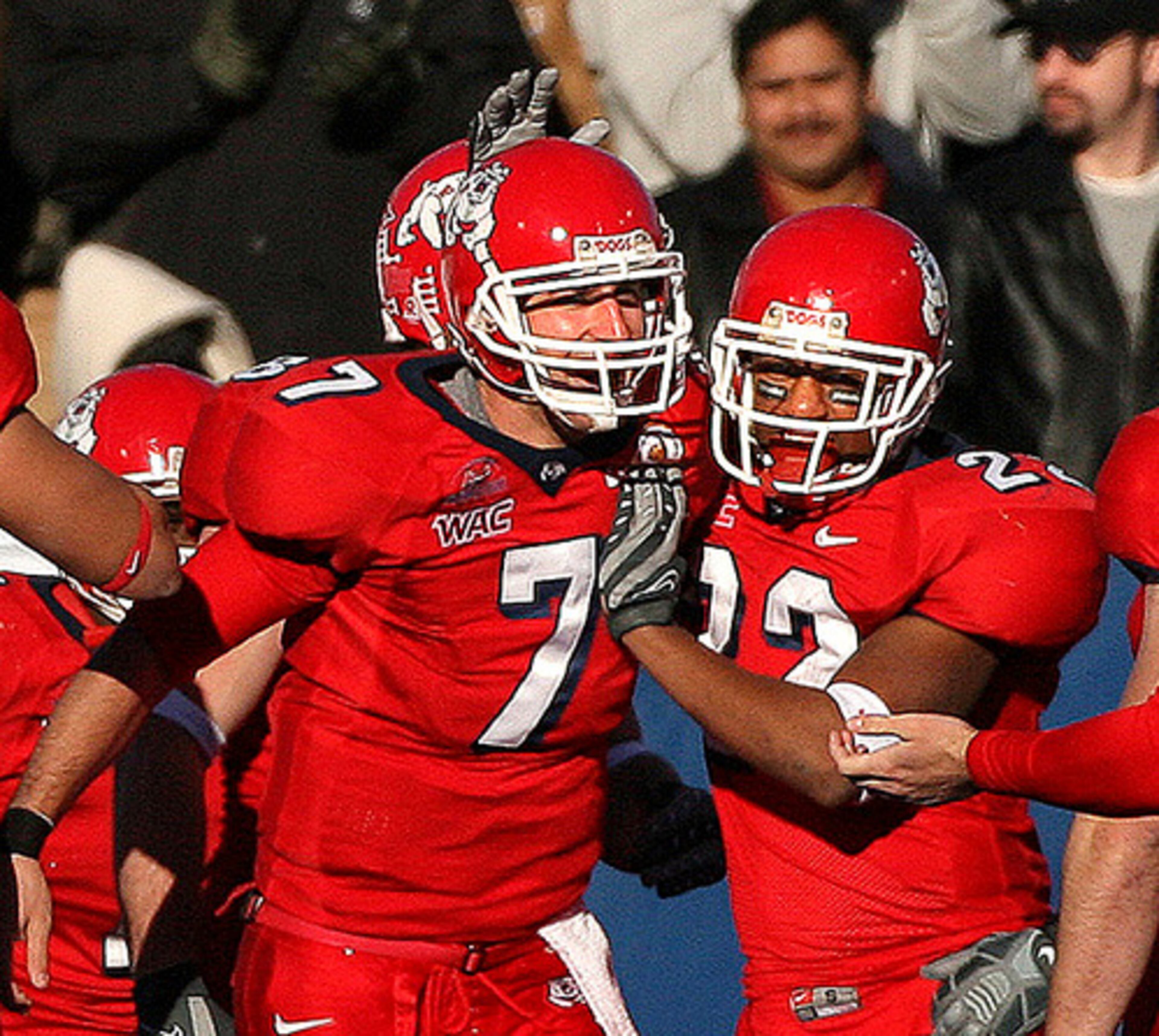 Fresno State's Tom Brandstater (7) and Damon Jenkins (22) celebrate one of several touchdowns by the Bulldogs.