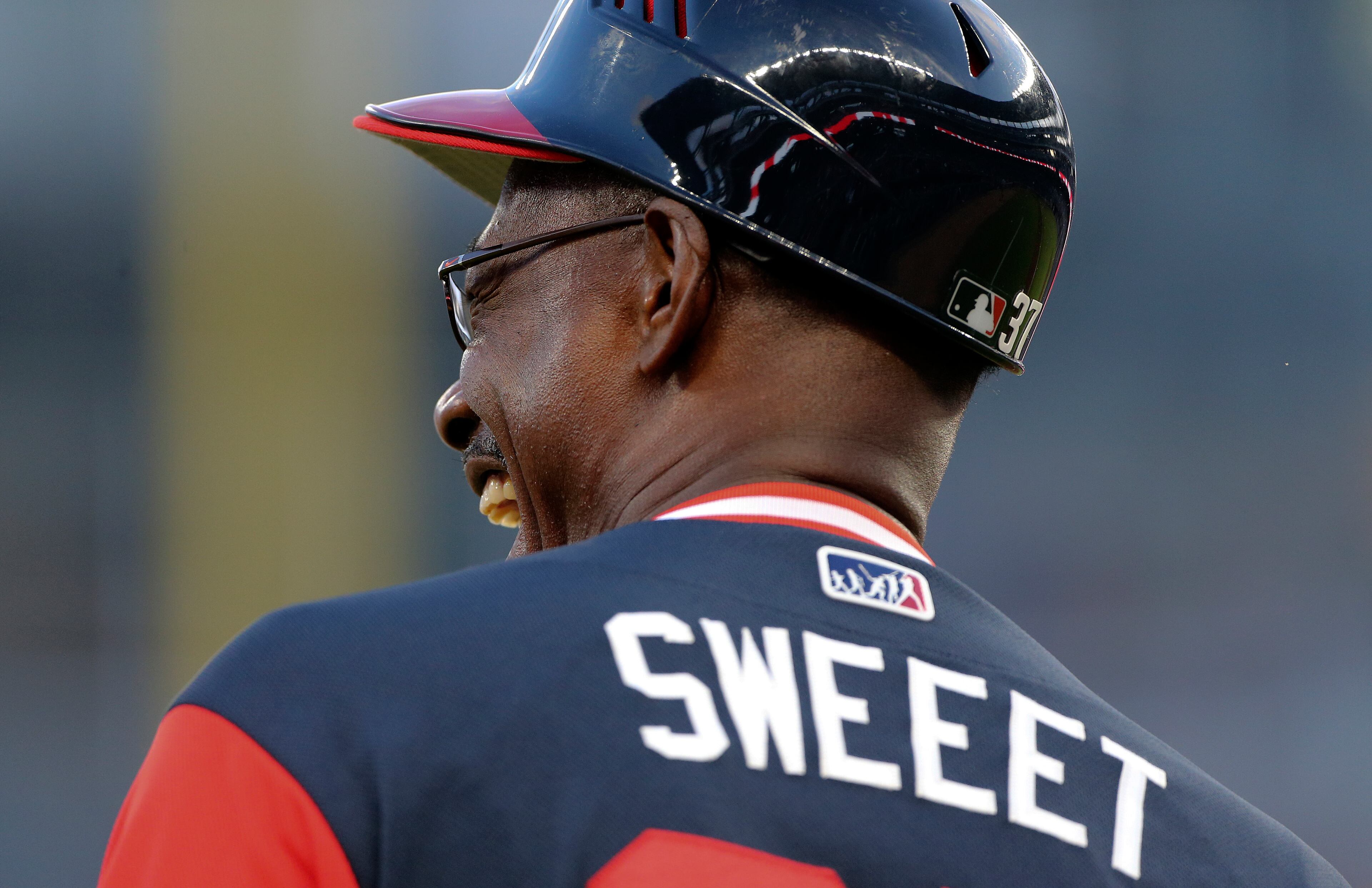 Atlanta Braves third base coach Ron Washington (37) wears a special jersey as he laughs with an umpire before the first inning of a baseball game against the Colorado Rockies Friday, Aug. 25, 2017, in Atlanta. (AP Photo/John Bazemore)
