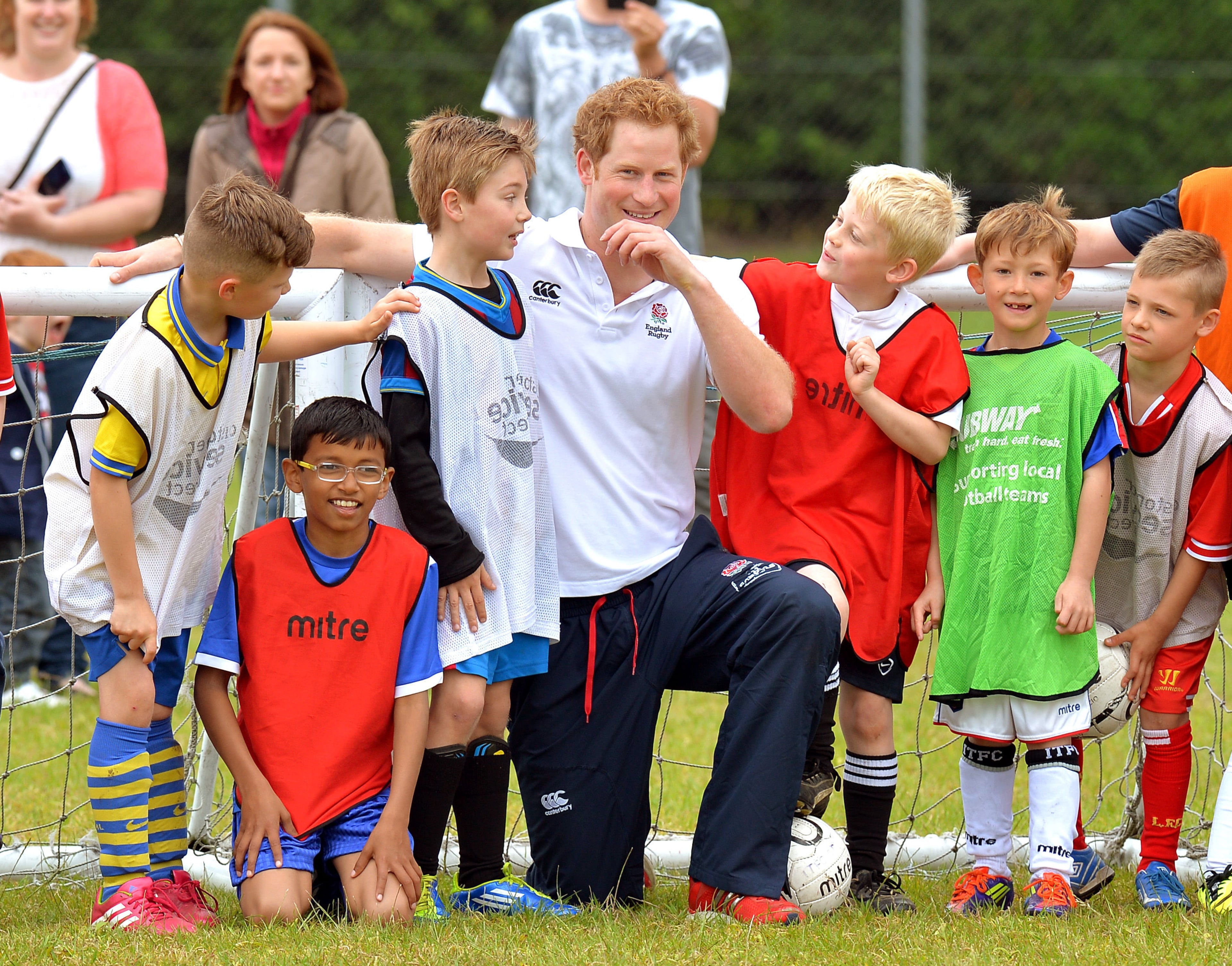 Britain's Prince Harry poses with boys after a short soccer kick about at the Inspire Suffolk centre for young people in Ipswich, eastern England, Thursday May 29, 2014. The prince began his day at the youth organisation which uses education and sport to improve young people's lives. (AP Photo/John Stillwell, Pool)