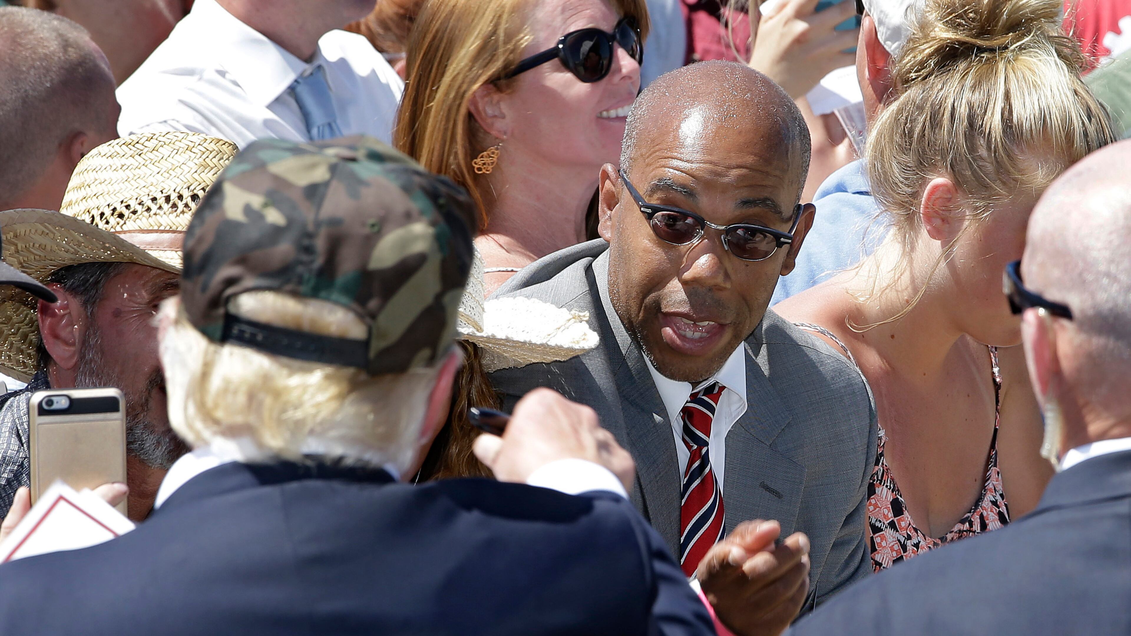 In this photo taken June 3, 2016, Republican presidential candidate Donald Trump, left, talks to Gregory Cheadle as he leaves a campaign rally at the Redding Municipal Airport, in Redding, Calif.
