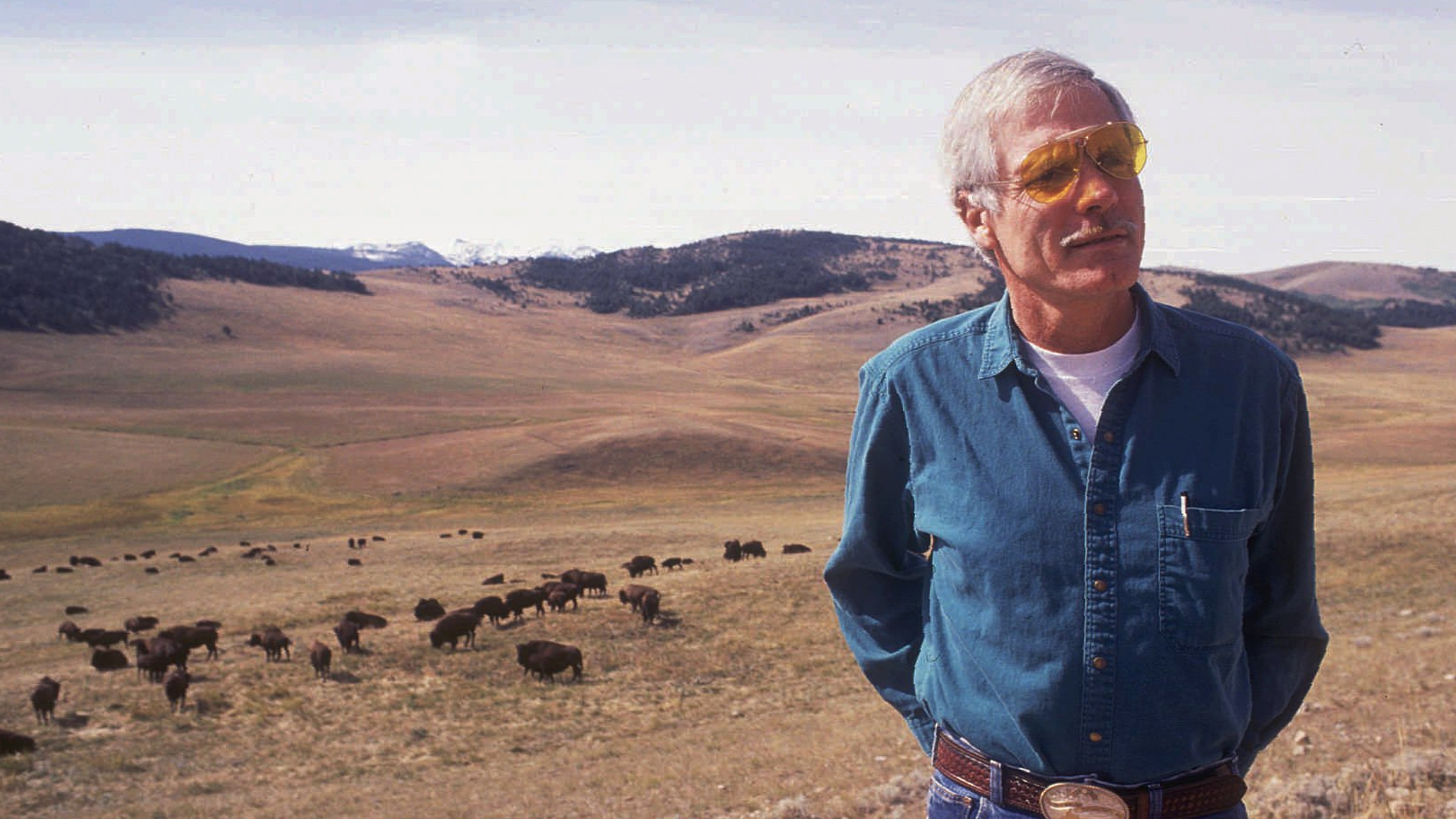 FILE - Ted Turner poses near a herd of his bison in September 1991 at his Flying D Ranch near Bozeman, Mont. (Linda Best/Bozeman Daily Chronicle via AP, File)