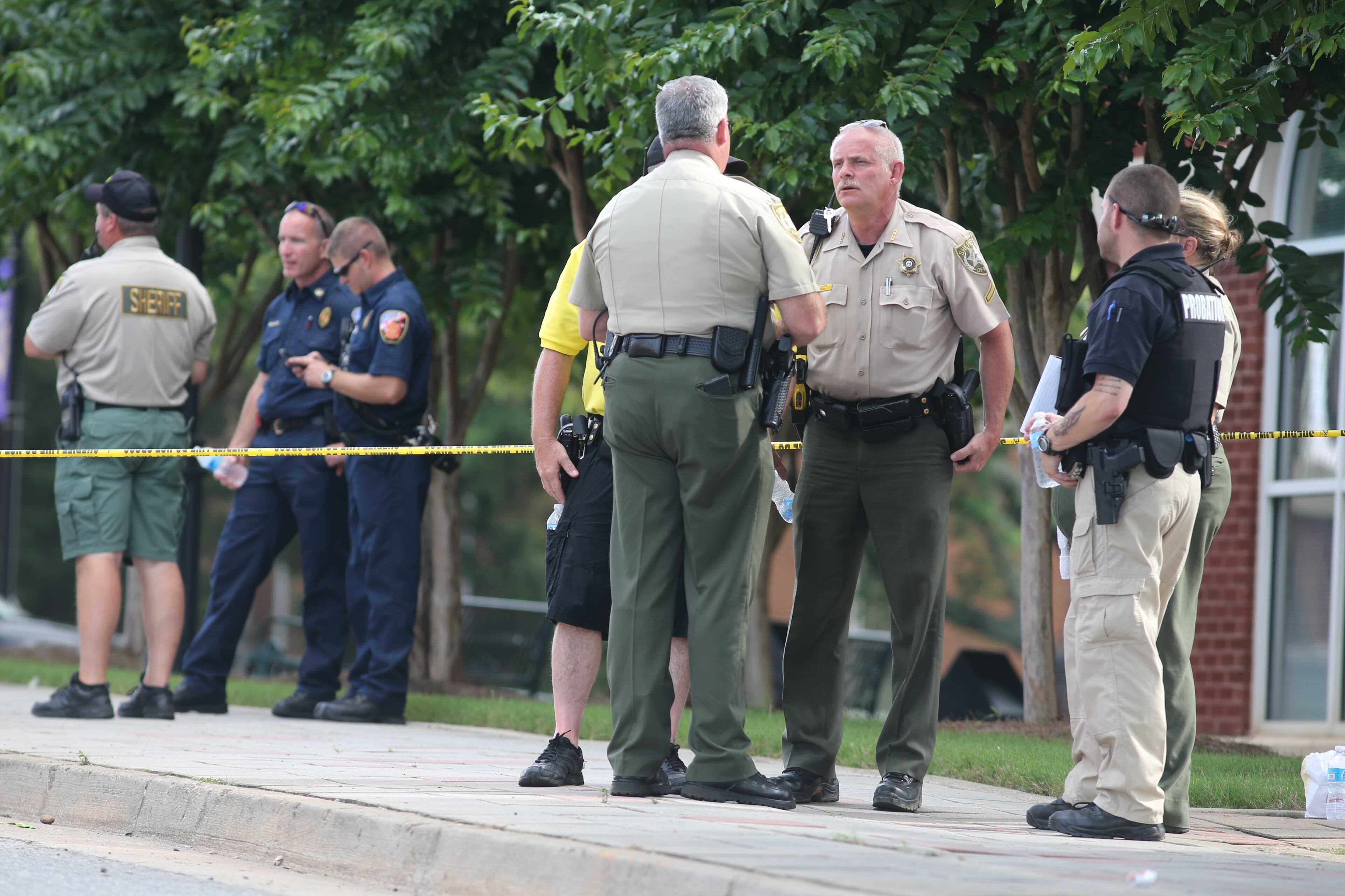 Authorities investigate the scene of shooting that took place in front of the Forsyth County courthouse in Cumming, Ga., on June 6, 2014.