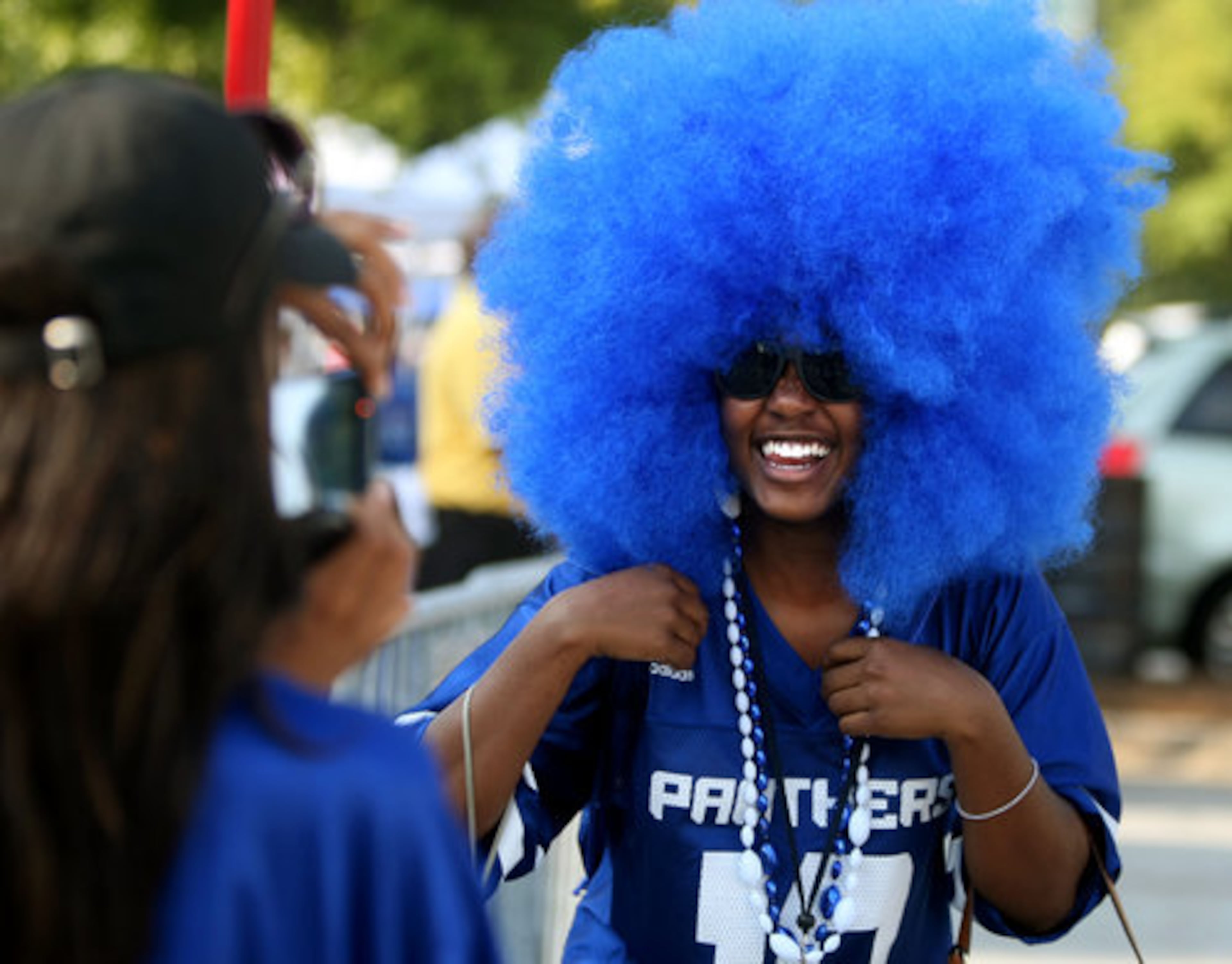 Georgia State University freshman Ruby Wesby, of Augusta, wears a large blue wig as she shows her school spirit as fellow freshman Jessical Loyd, of Atlanta, left, takes her photograph in preparation for GSU's inaugural game against Shorter College in the Georgia Dome Thursday night in Atlanta, Ga., Sept. 2, 2010.