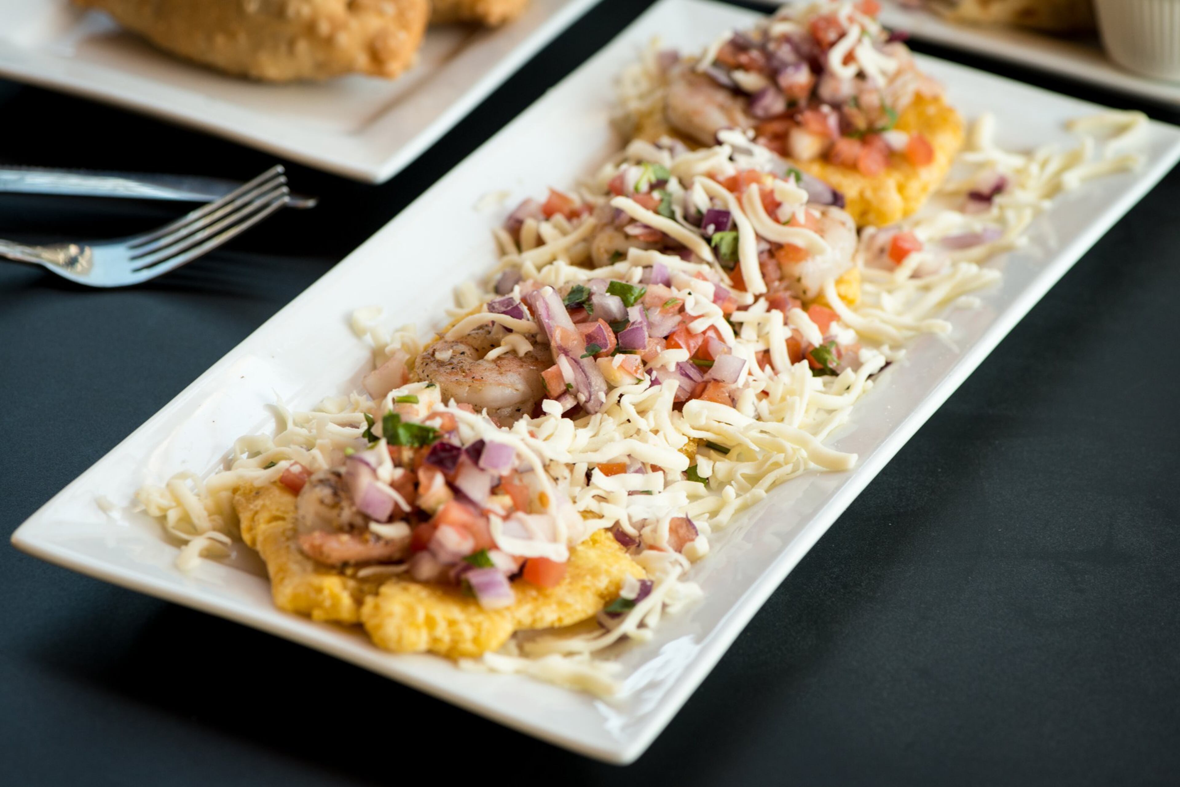 Papi's tostones supremos: fried green plantains, shredded mozzarella, pico de gallo, and shrimp. CONTRIBUTED BY MIA YAKEL