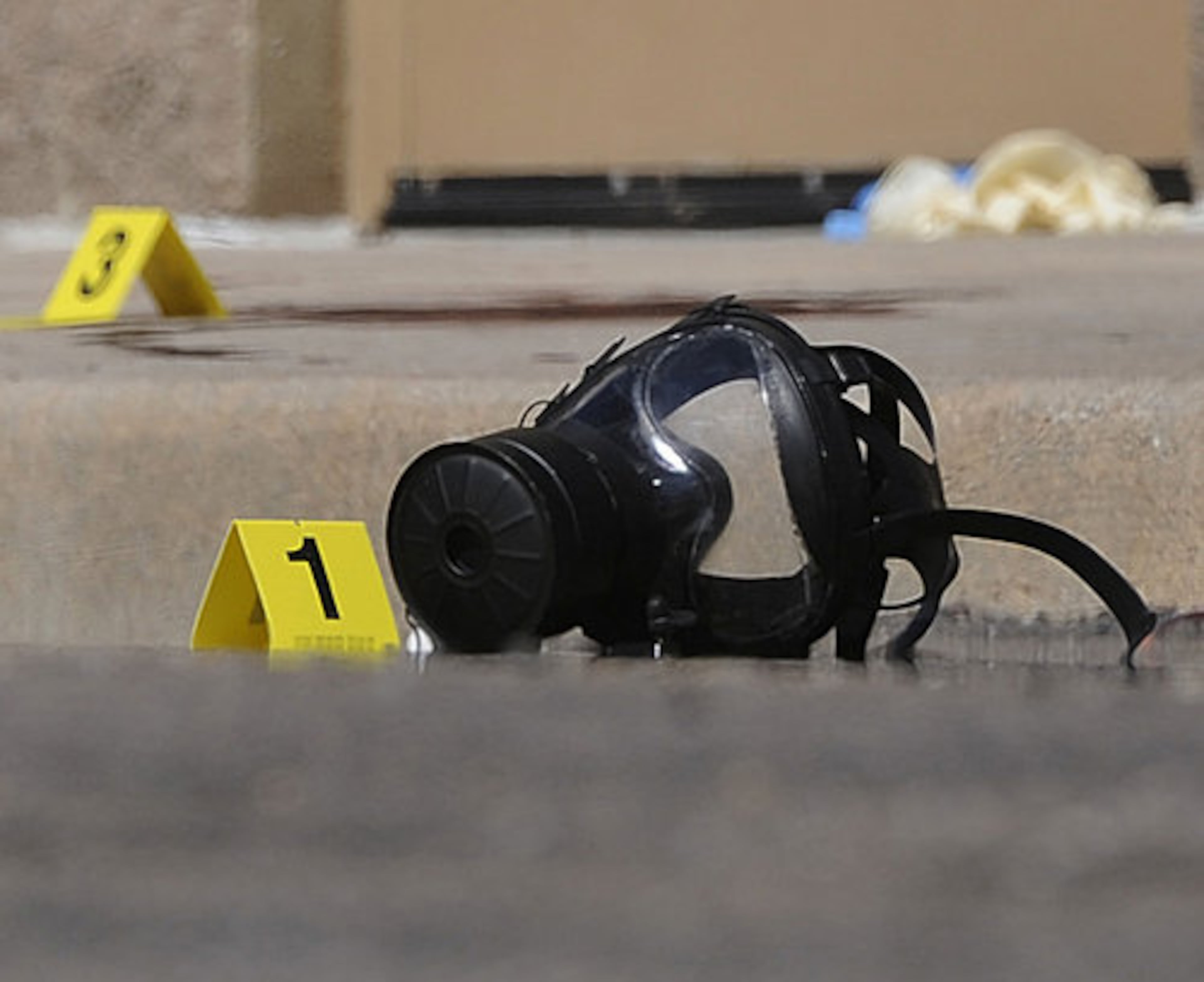 A gas mask was marked as the first piece of evidence in a criminal investigation outside the parking lot behind the Century 16 movie after a shooting at the theatre Friday, July 20, 2012. A gunman wearing a gas mask set off an unknown gas and fired into the crowded movie theater killing 12 people and injuring at least 50 others, authorities said. The suspect is identified as 24-year-old James Holmes.