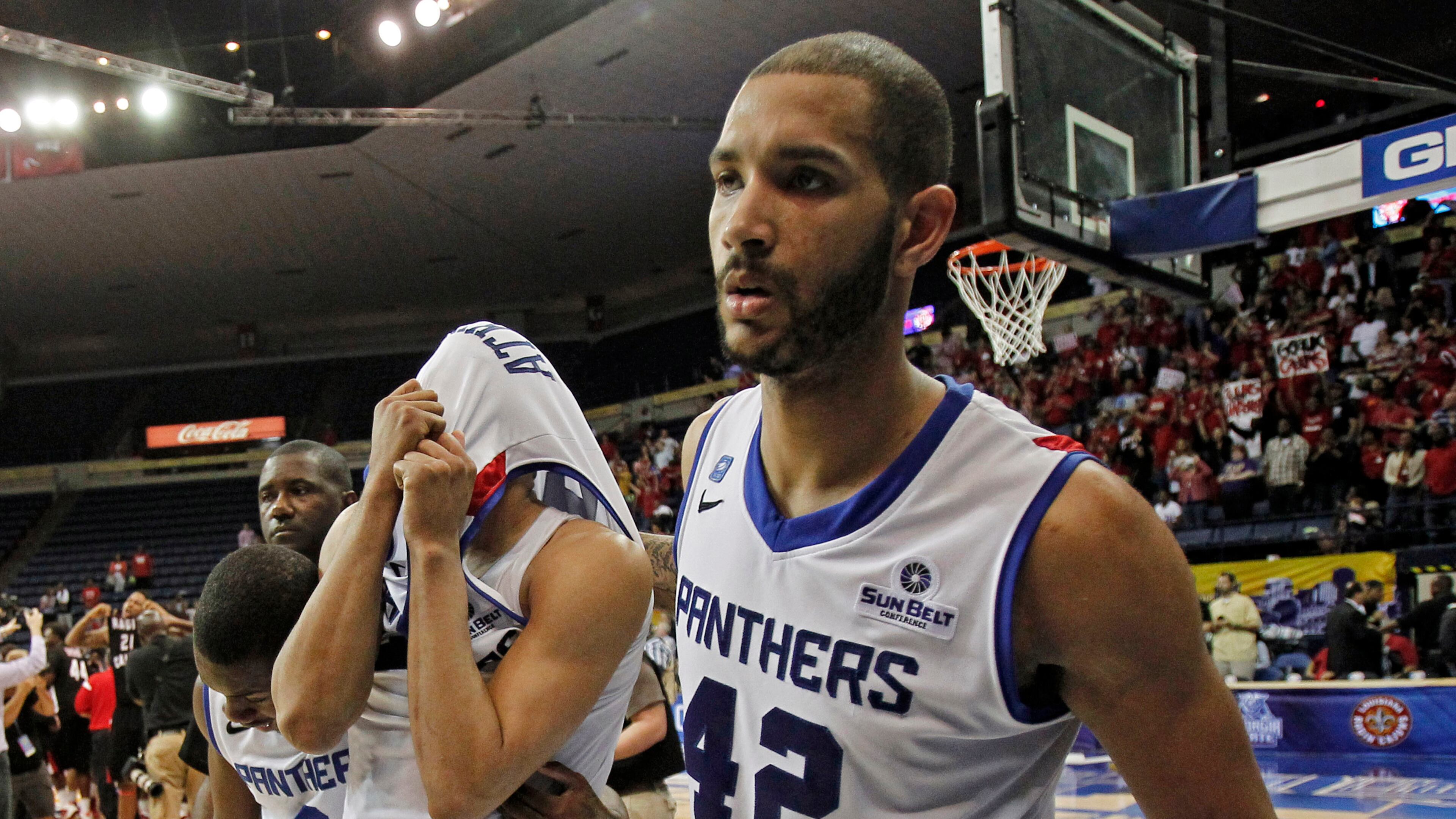 Georgia State forward Curtis Washington (42) and Georgia State guard Ryann Green (2) help Georgia State forward Manny Atkins, center, off the court after they lost to Louisiana Lafayette in an NCAA college basketball game for the Sun Belt Conference tournament championship in New Orleans, Sunday, March 16, 2014. Louisiana Lafayette won 82-81. (AP Photo/Bill Haber)