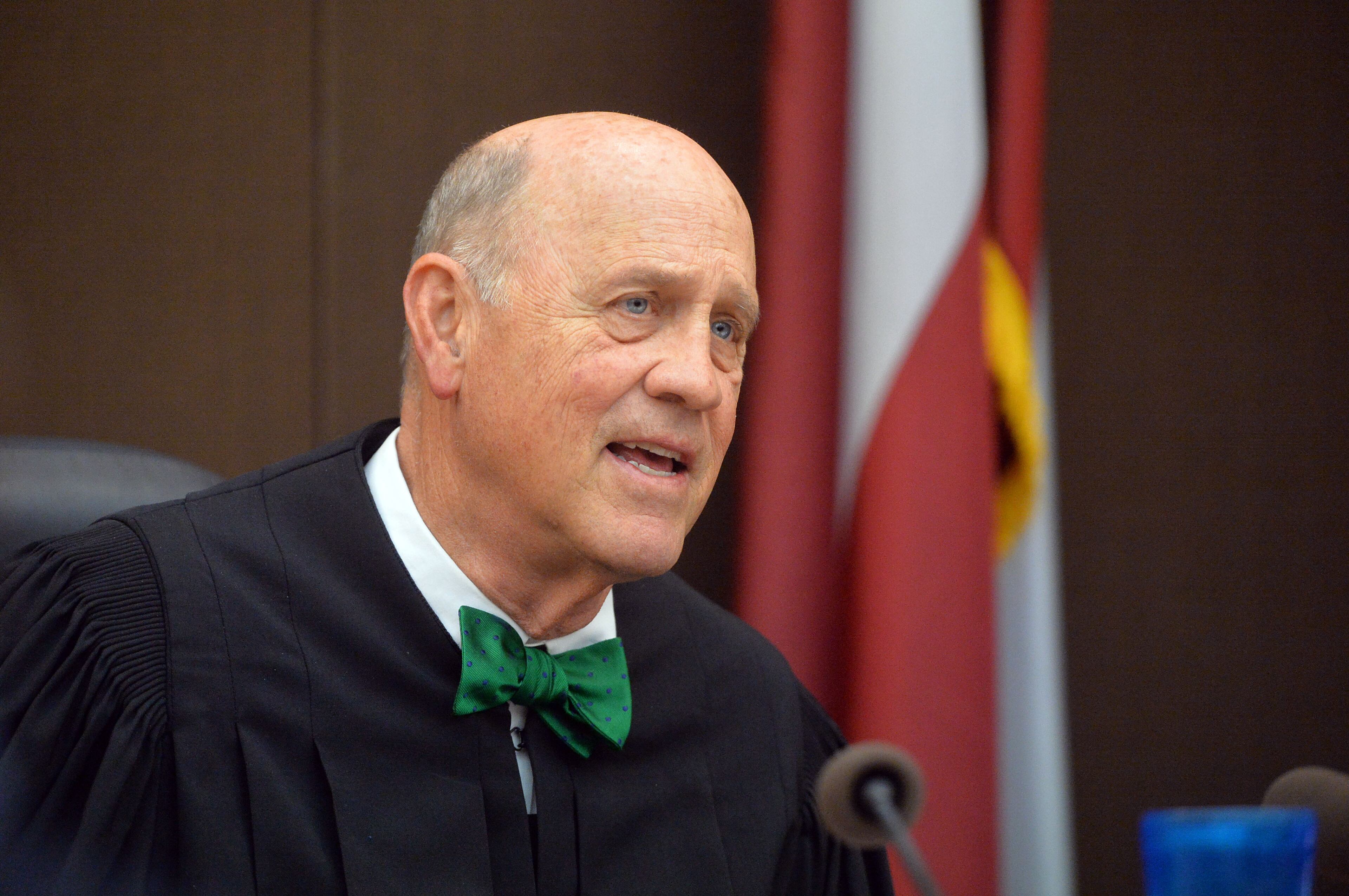 Fulton County Superior Court Judge Jerry Baxter makes a statement in court Tuesday before presenting defense attorney W. Scott Smith a "Green Peacock Award" in honor of St. Patrick's Day. (Atlanta Journal-Constitution, Kent D. Johnson, Pool)